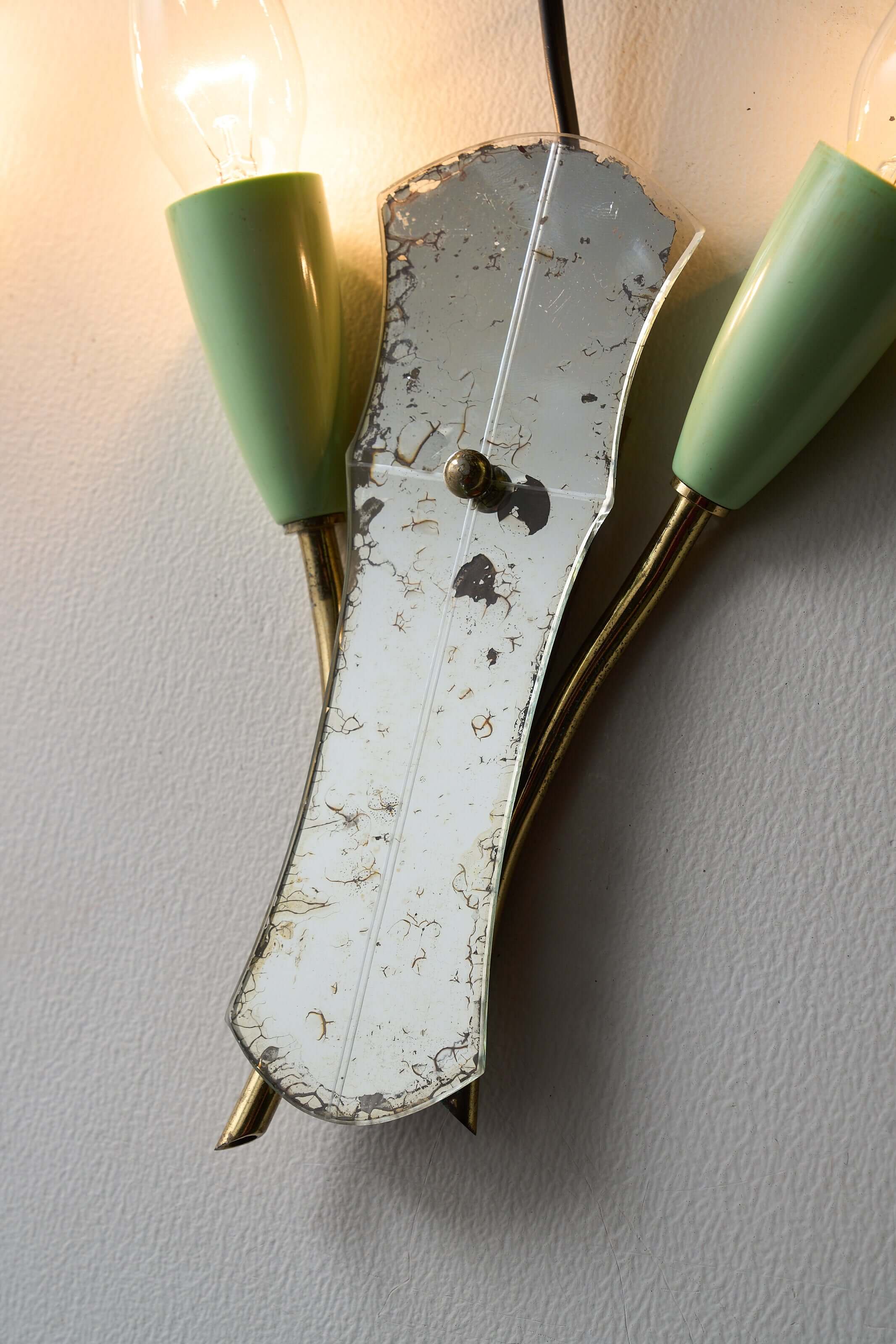 Brass and Mirrored Glass Wall Lamp, 1950s featuring a shaped mirror and pale green lampholders.