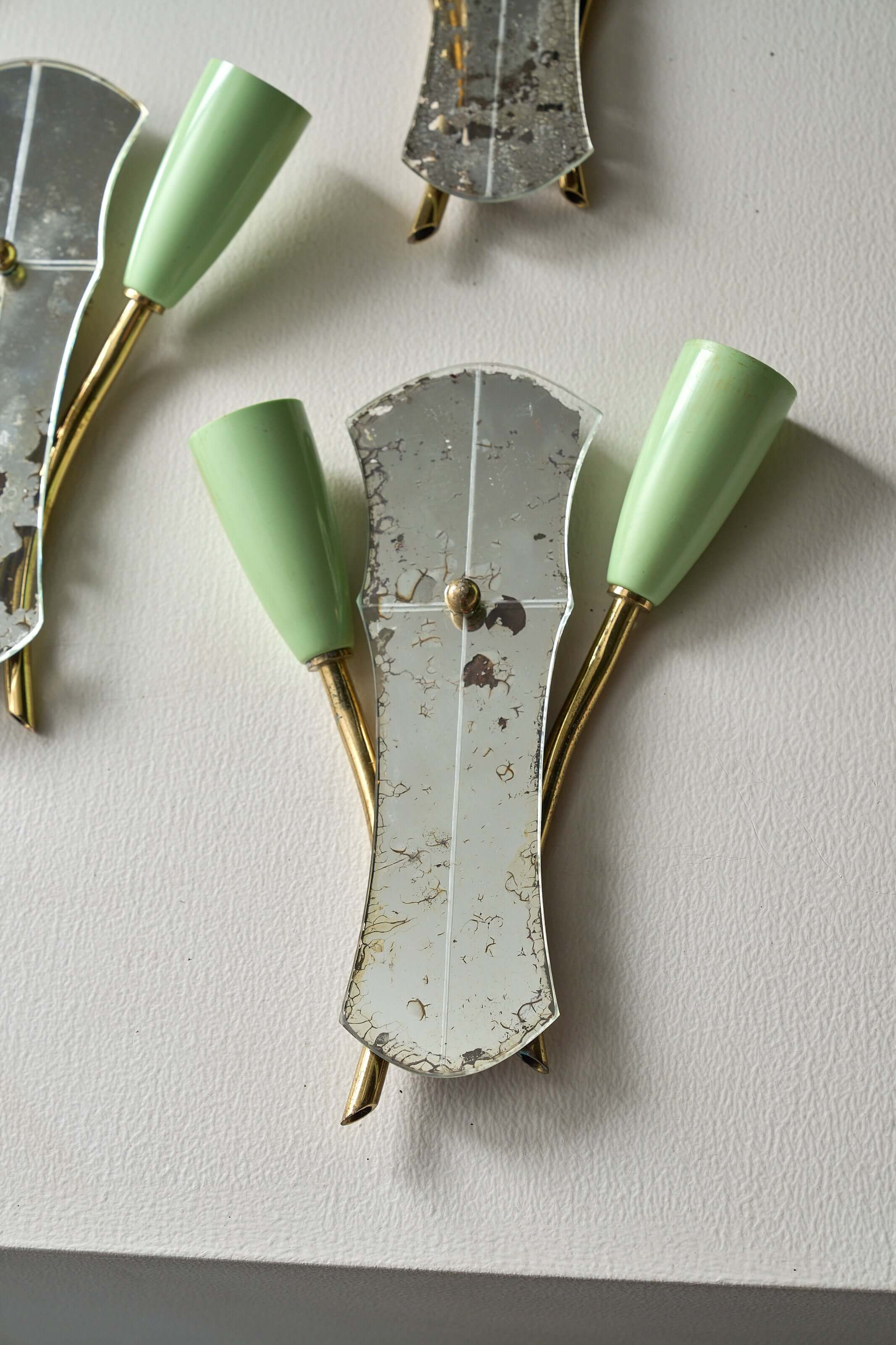 Brass and Mirrored Glass Wall Lamp, 1950s featuring a shaped mirror and pale green lampholders.