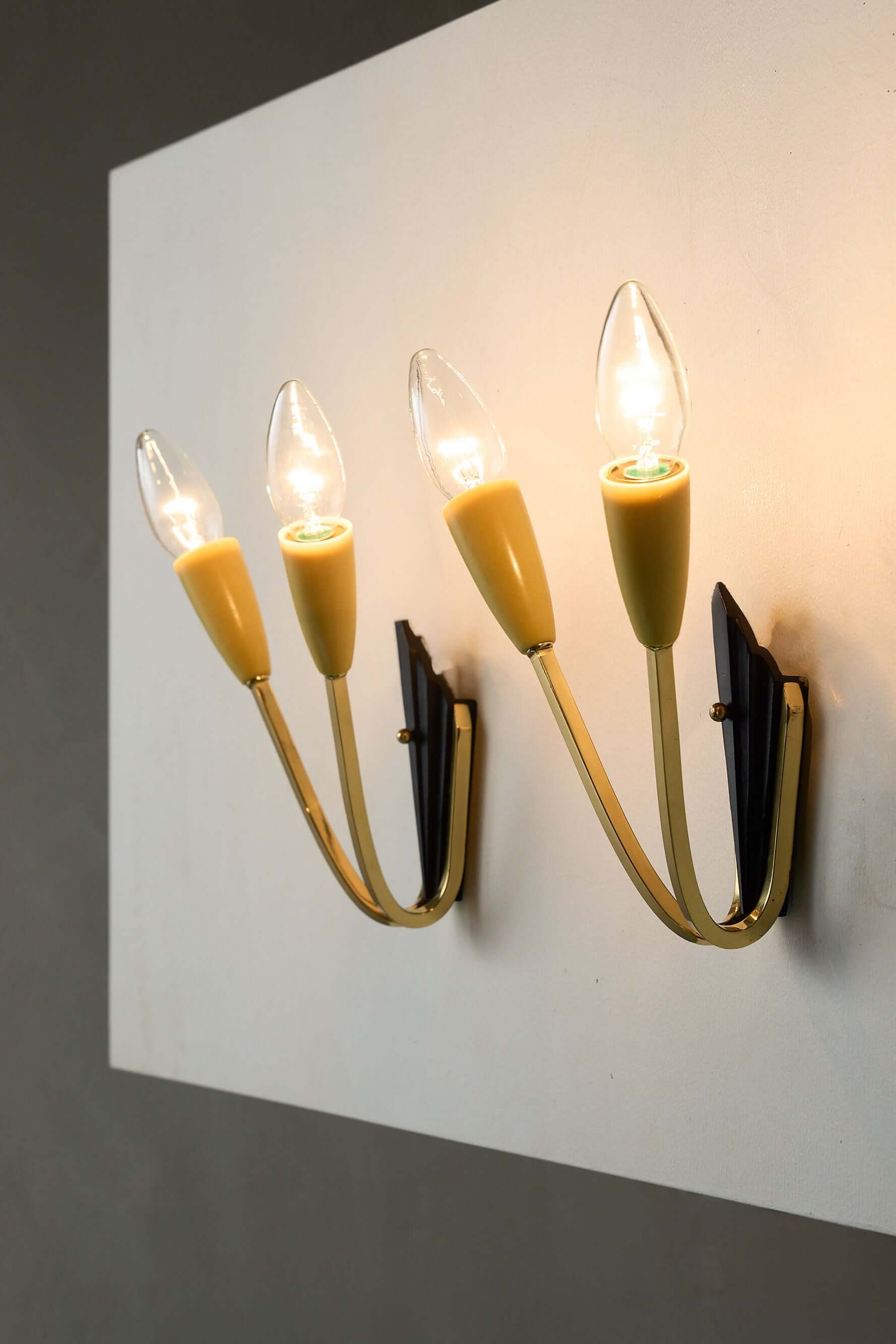 Geometric Brass and Black Wall Lamp, 1950s with pastel yellow light sockets and black base.
