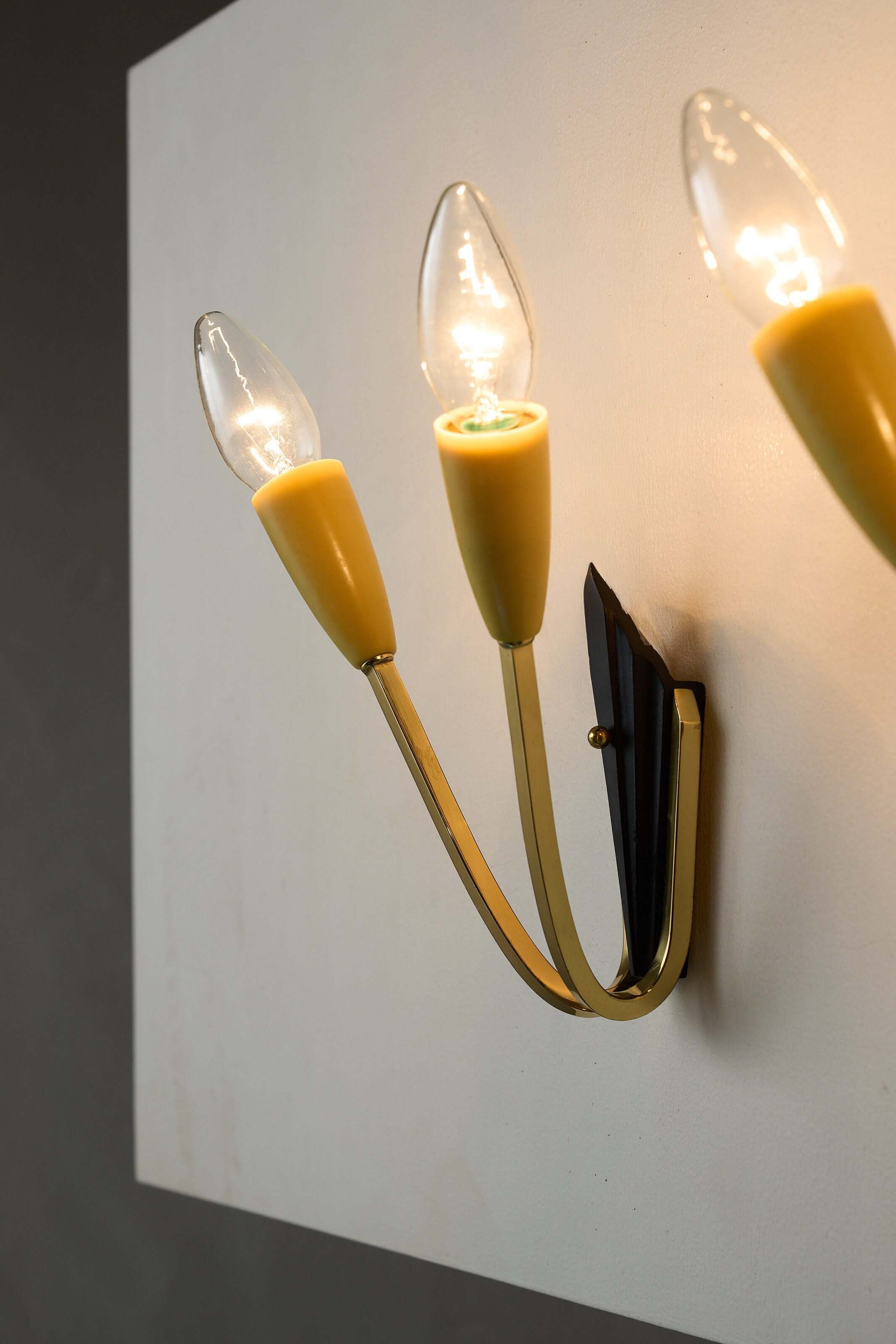 Geometric Brass and Black Wall Lamp, 1950s featuring yellow cone-shaped light sockets.