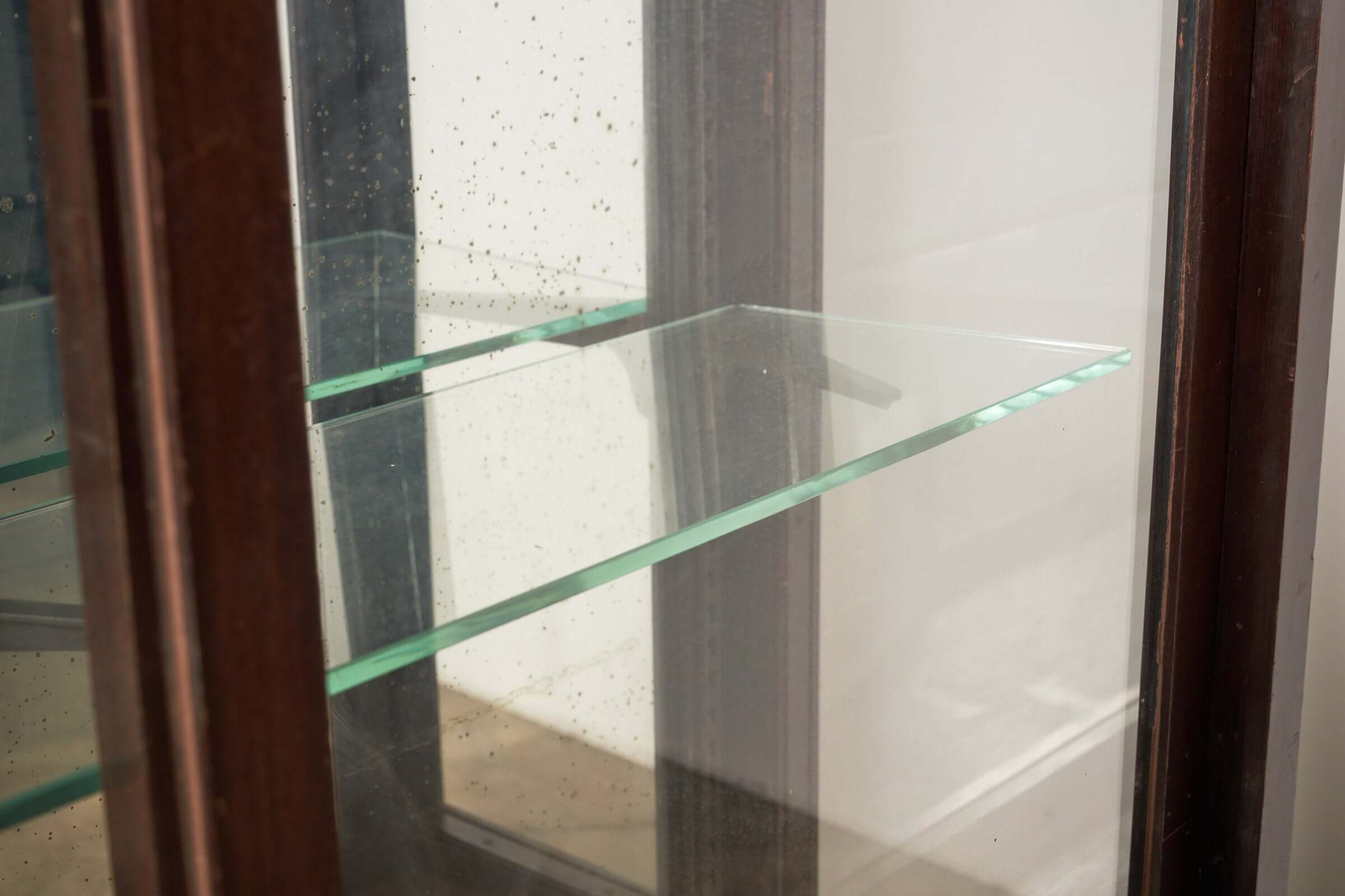 Interior view of the Art Deco Mirrored Display Cabinet with Sliding Doors showcasing glass shelves.