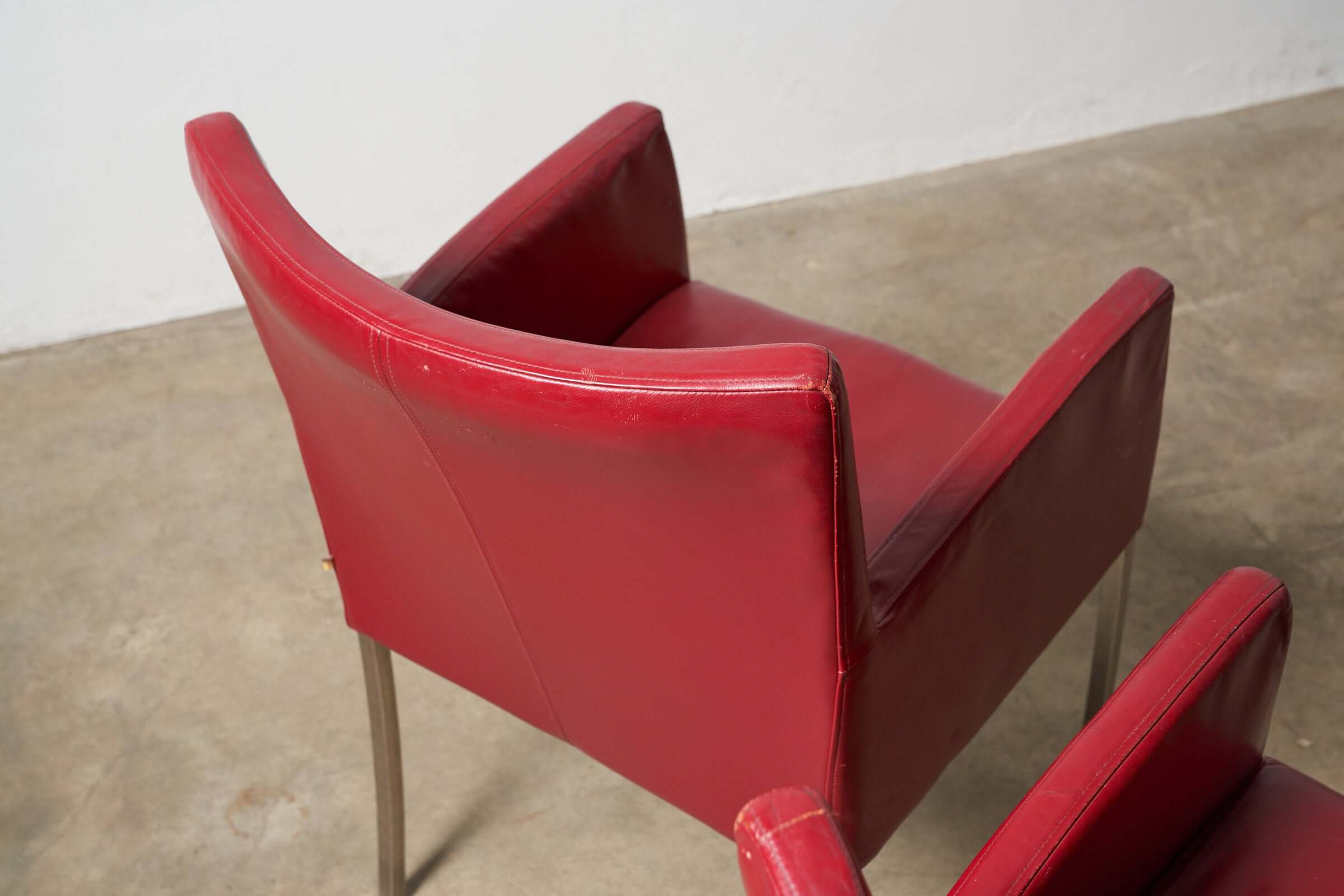 Red or Black Leather Armchairs in vibrant red, showcasing vintage design and soft leather texture.