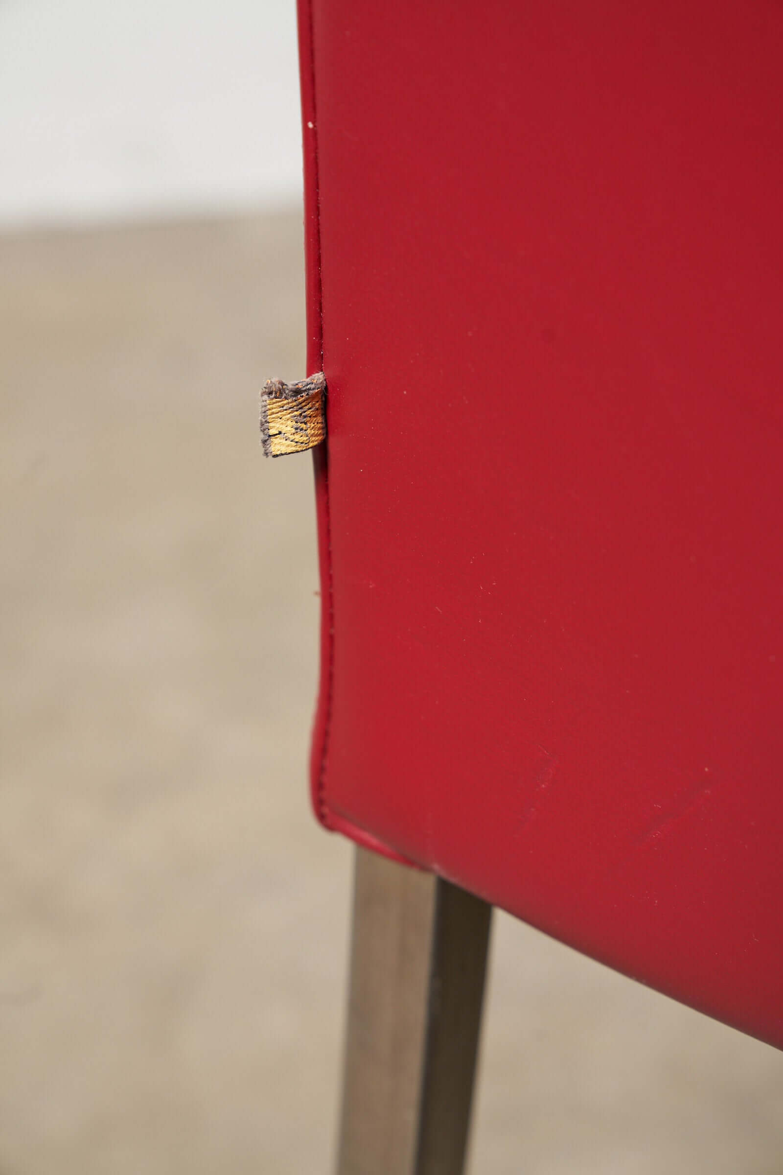 Close-up of a red leather armchair featuring a gold button detail, part of the Red or Black Leather Armchairs collection.