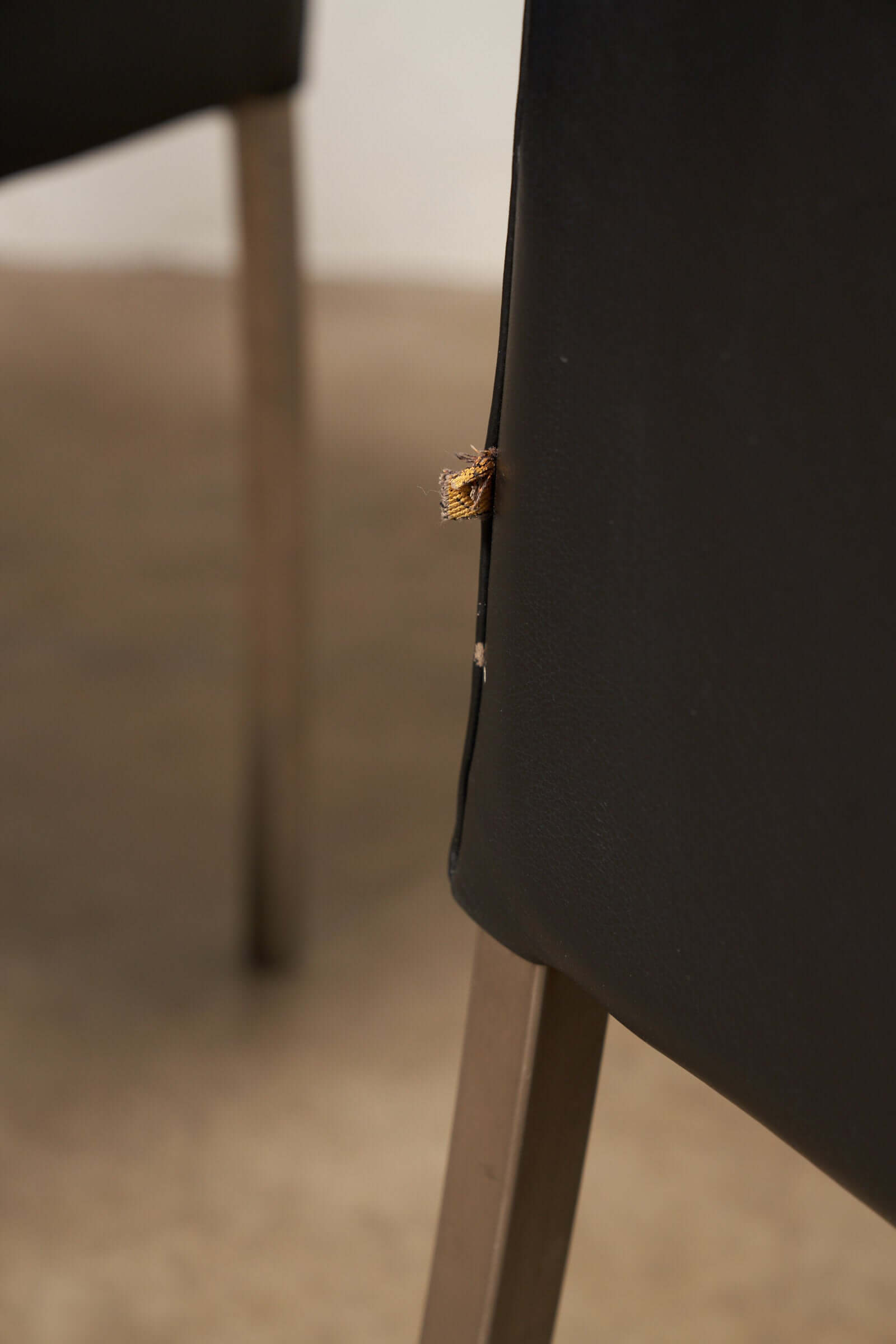 Close-up of wear on a Red or Black Leather Armchair highlighting vintage character and detailing.
