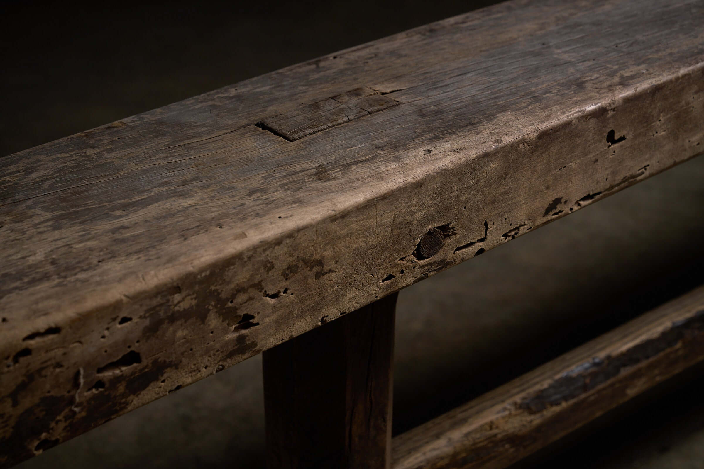 Spanish Trestle Bench in Solid Wood showcasing thick rectangular top with weathered patina and visible joinery details.