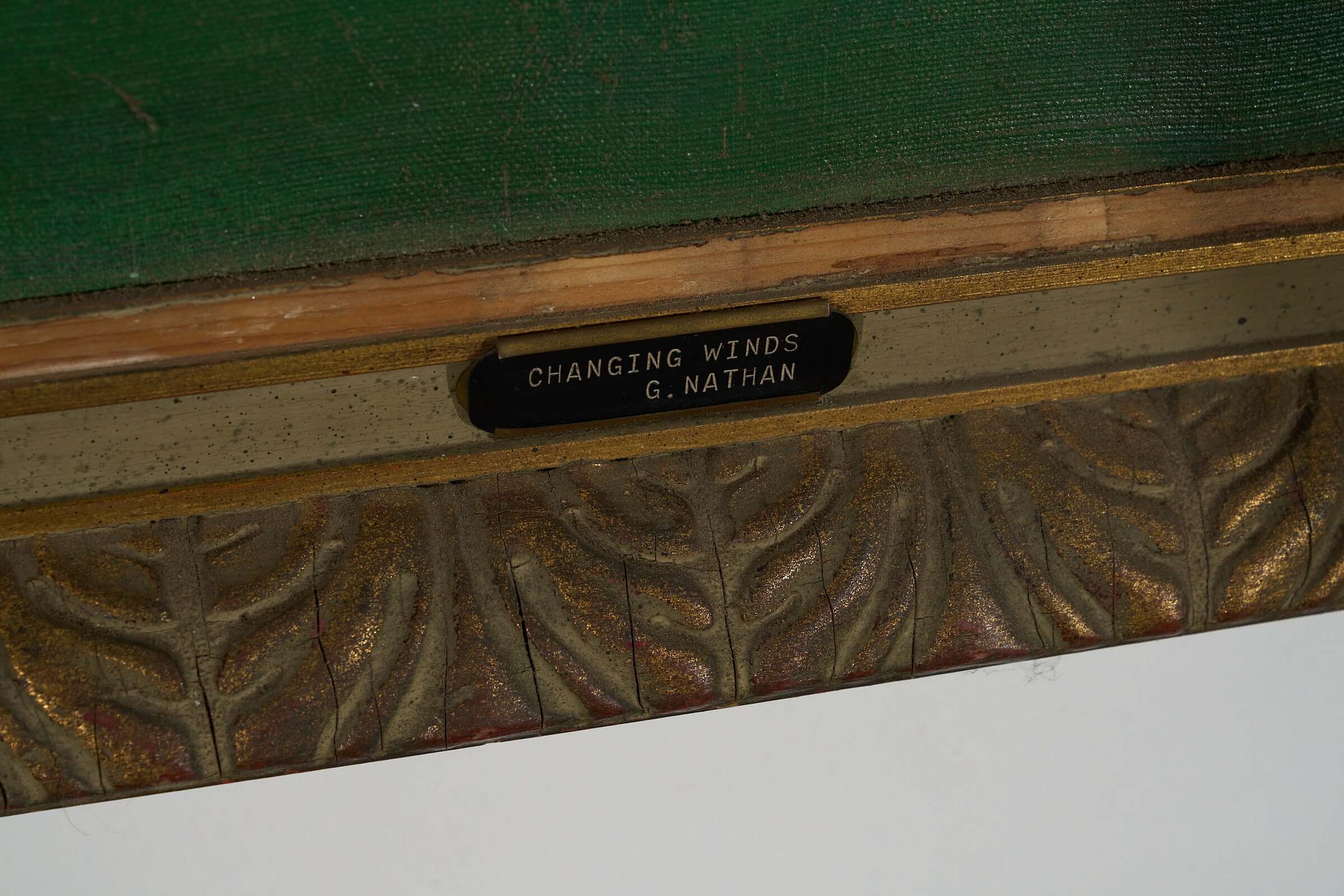 Detail of the plaque depicting "Changing Winds," signed by the artist G. Nathan, showcasing intricate framing.