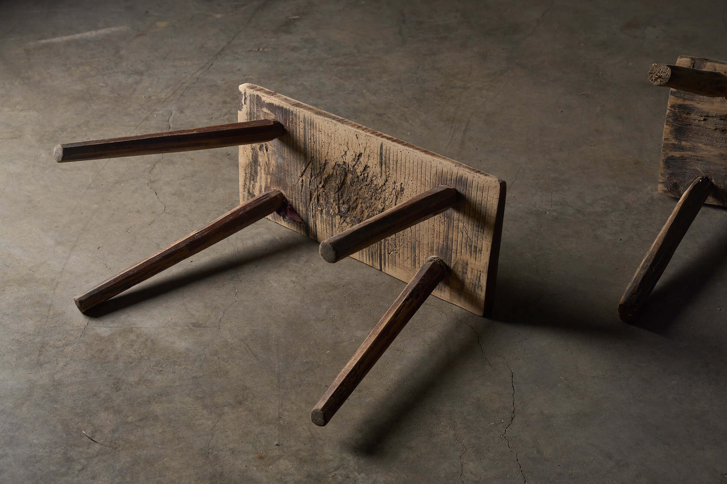 Antique Wooden Stools showcasing unique structural design and rich texture on a gray surface.
