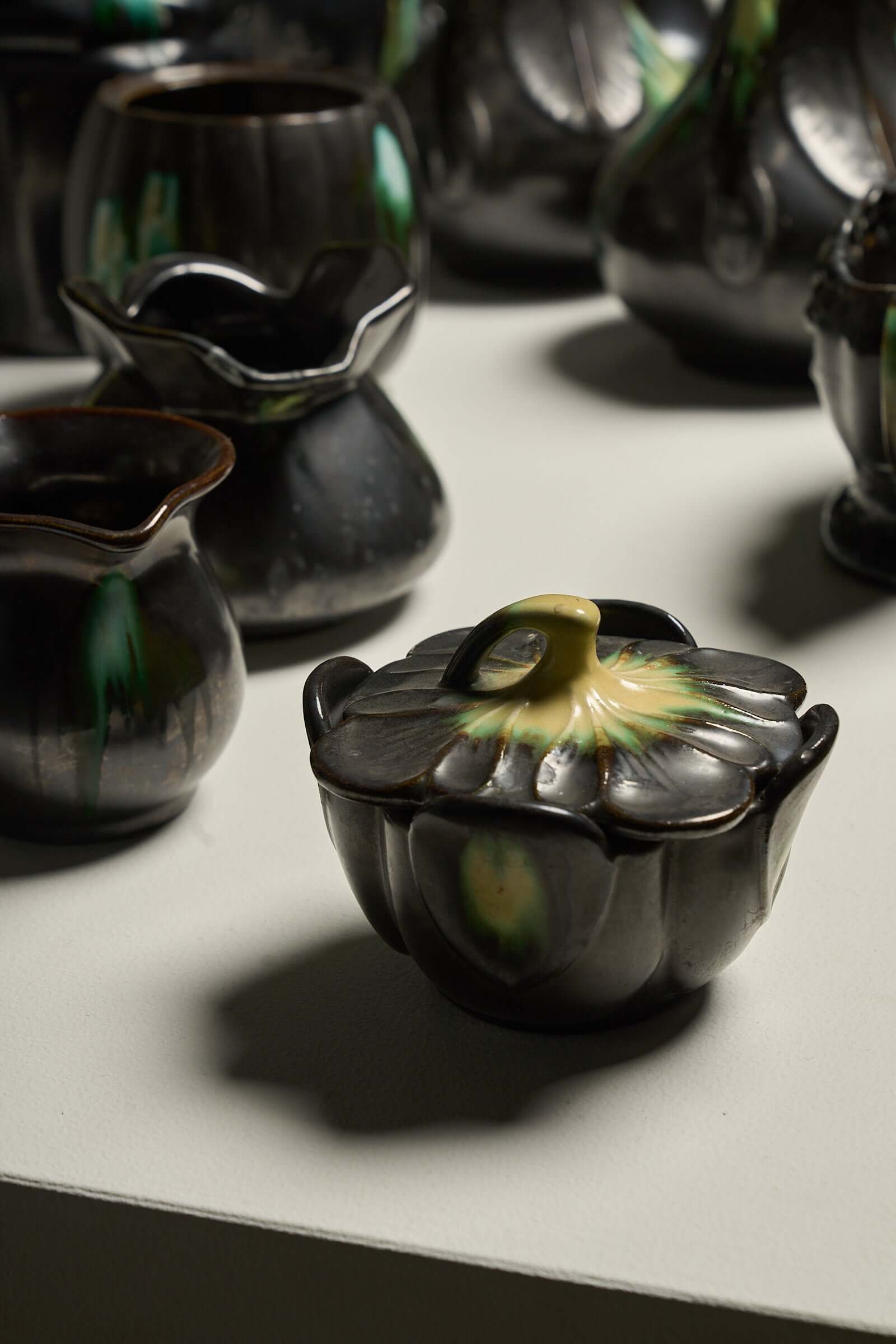 Large Collection of Belgian Art Deco Drip Glaze Ceramics 1920s featuring a decorative black and green glazed vessel.