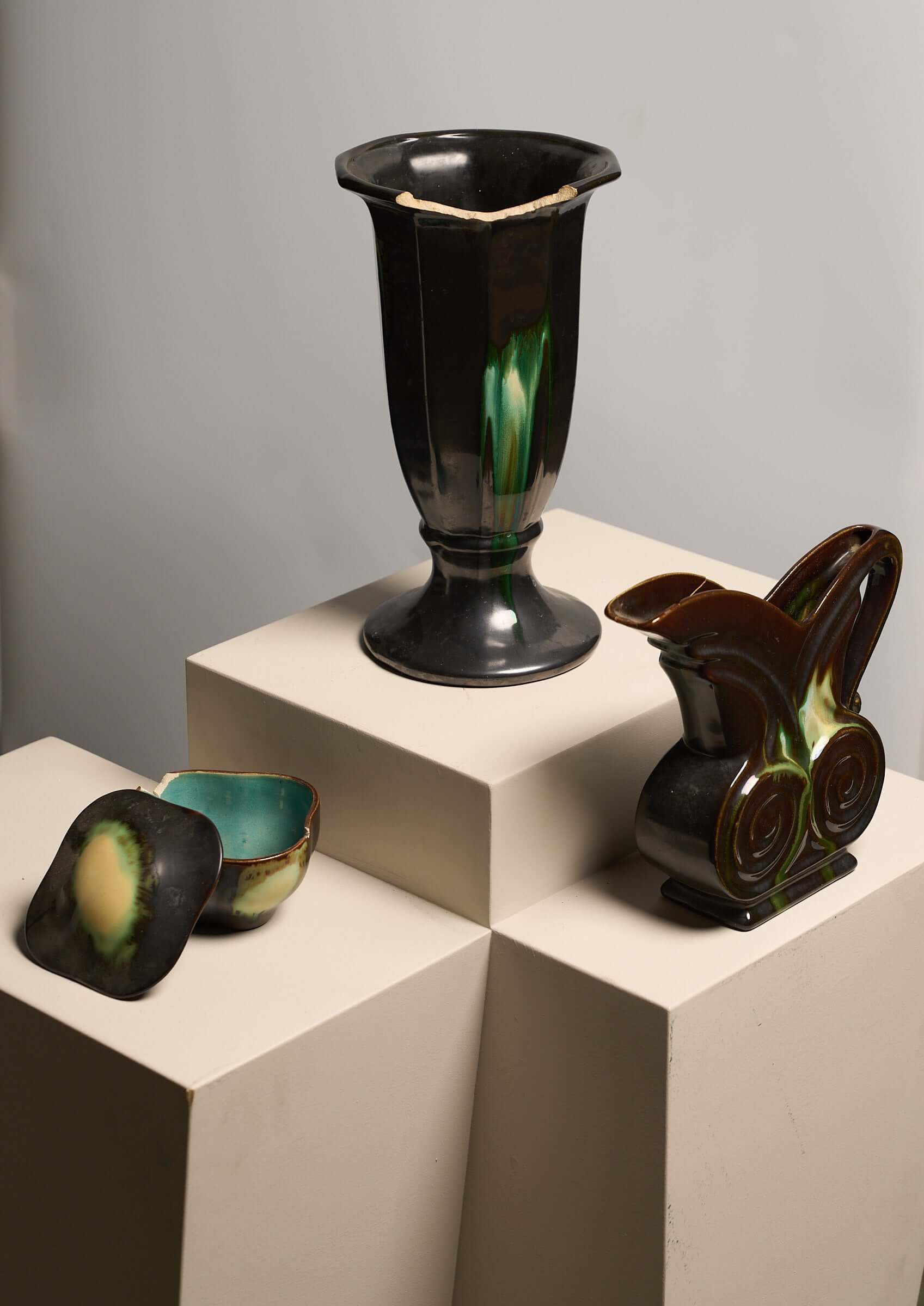 Large Collection of Belgian Art Deco Drip Glaze Ceramics 1920s displayed on pedestals, showcasing distinct pitchers and vases.