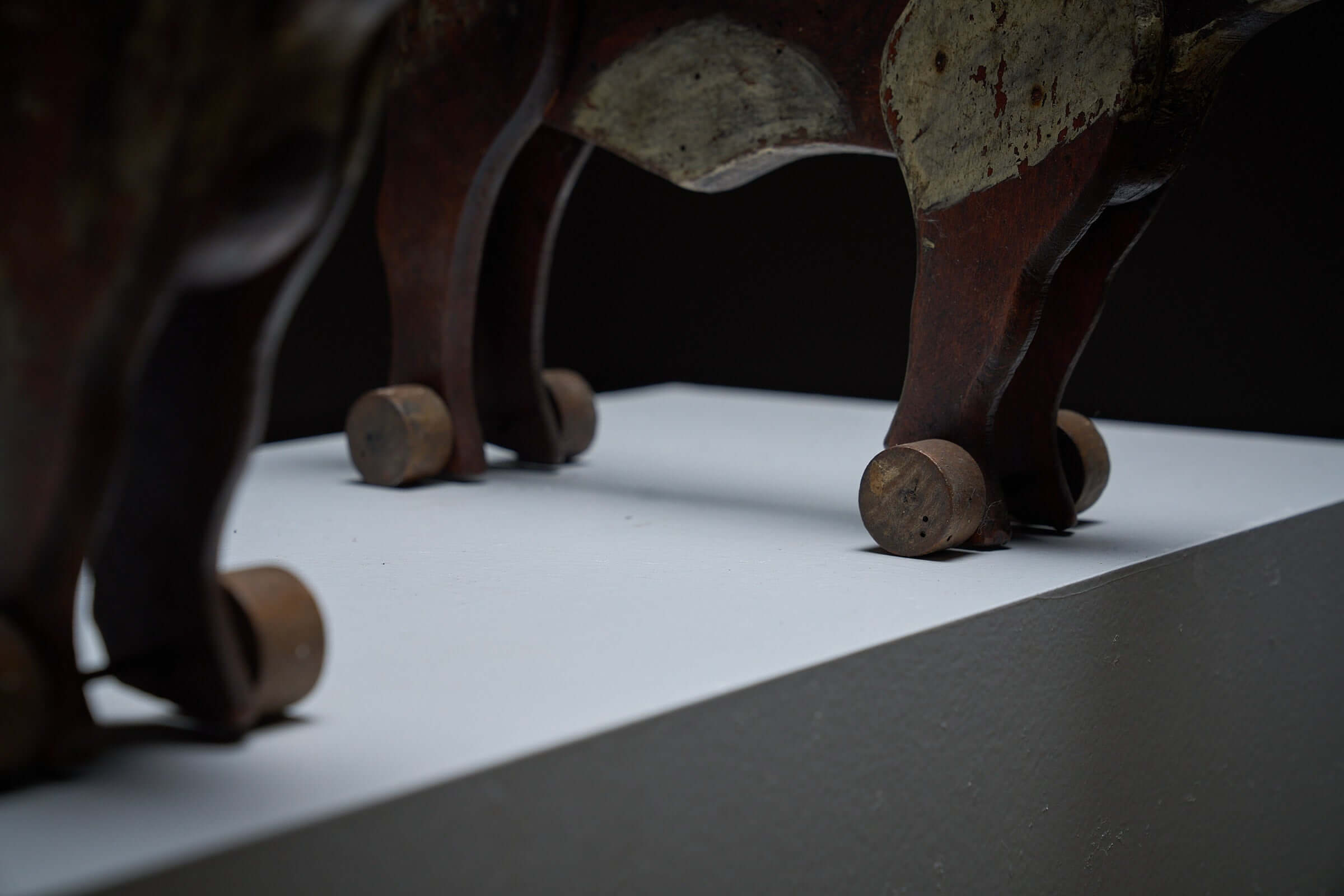 Pair of Antique Articulated Wooden Cow Pull Toys on display, showcasing wheels and rustic details.