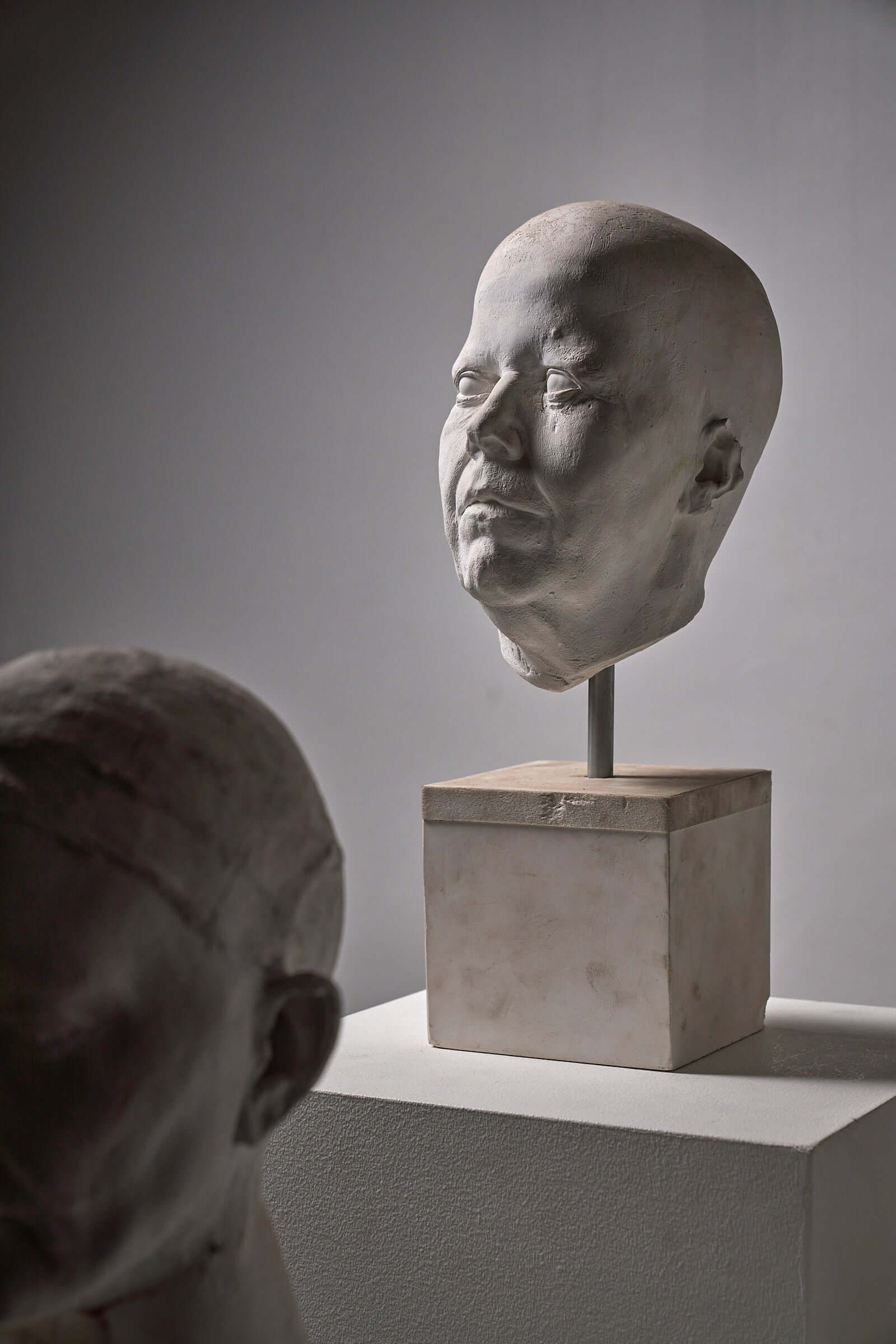 Set of Four Plaster Heads on Plinths showcased in an art space with detailed life casts.