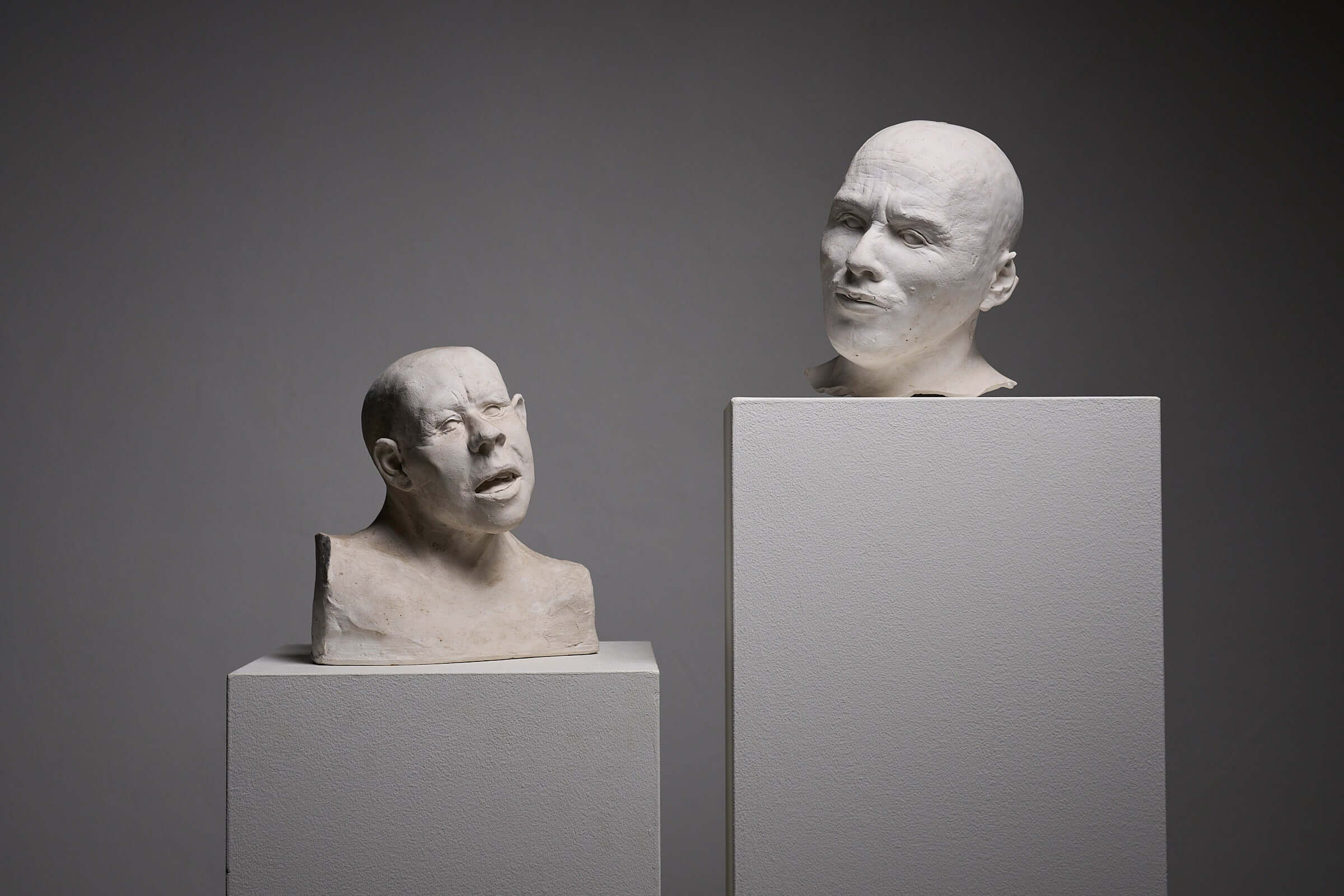 Set of Two Plaster Heads on Plinths displayed against a neutral background.