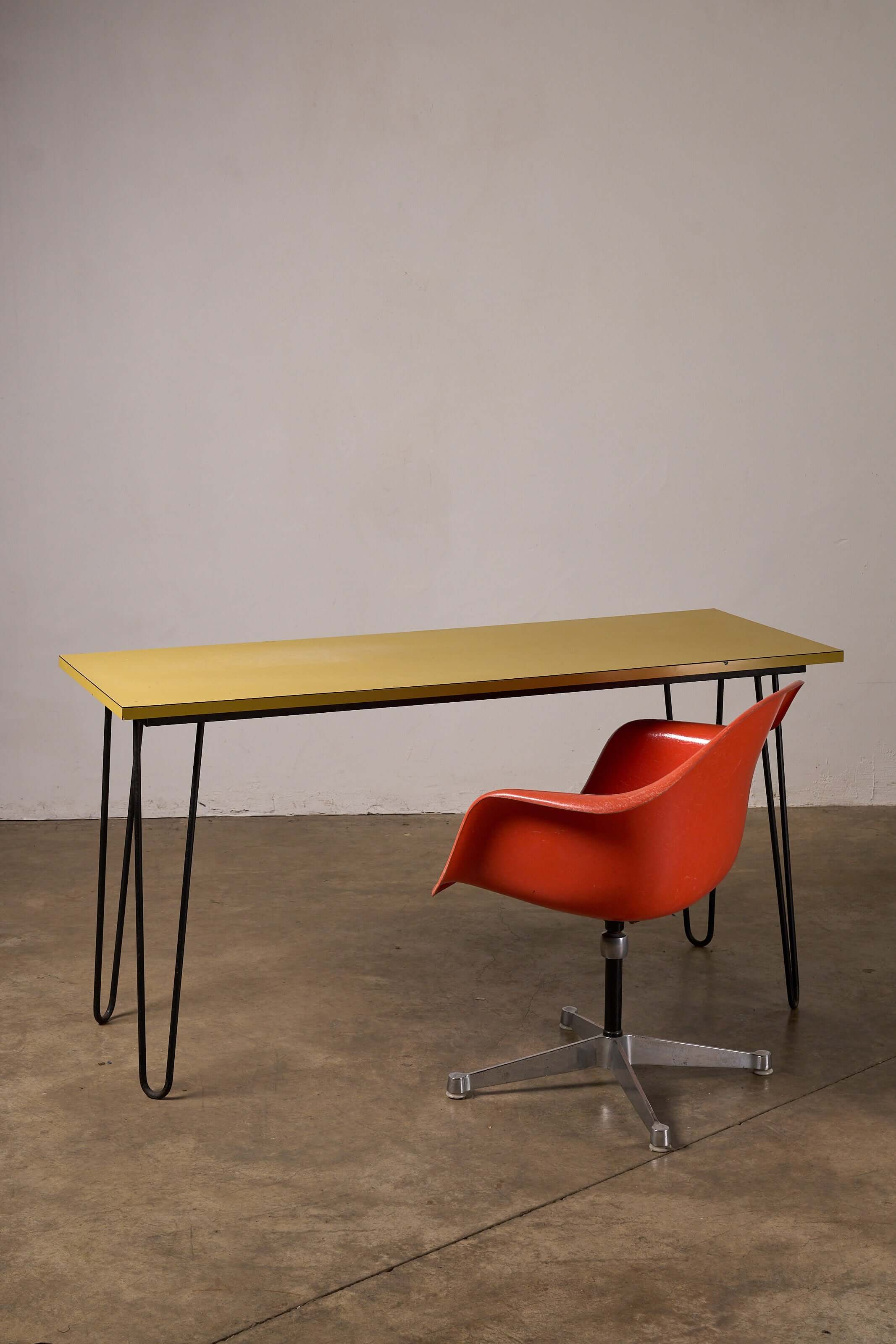 Mid-Century Yellow Console or Desk with black metal legs and orange chair in a stylish interior setting.