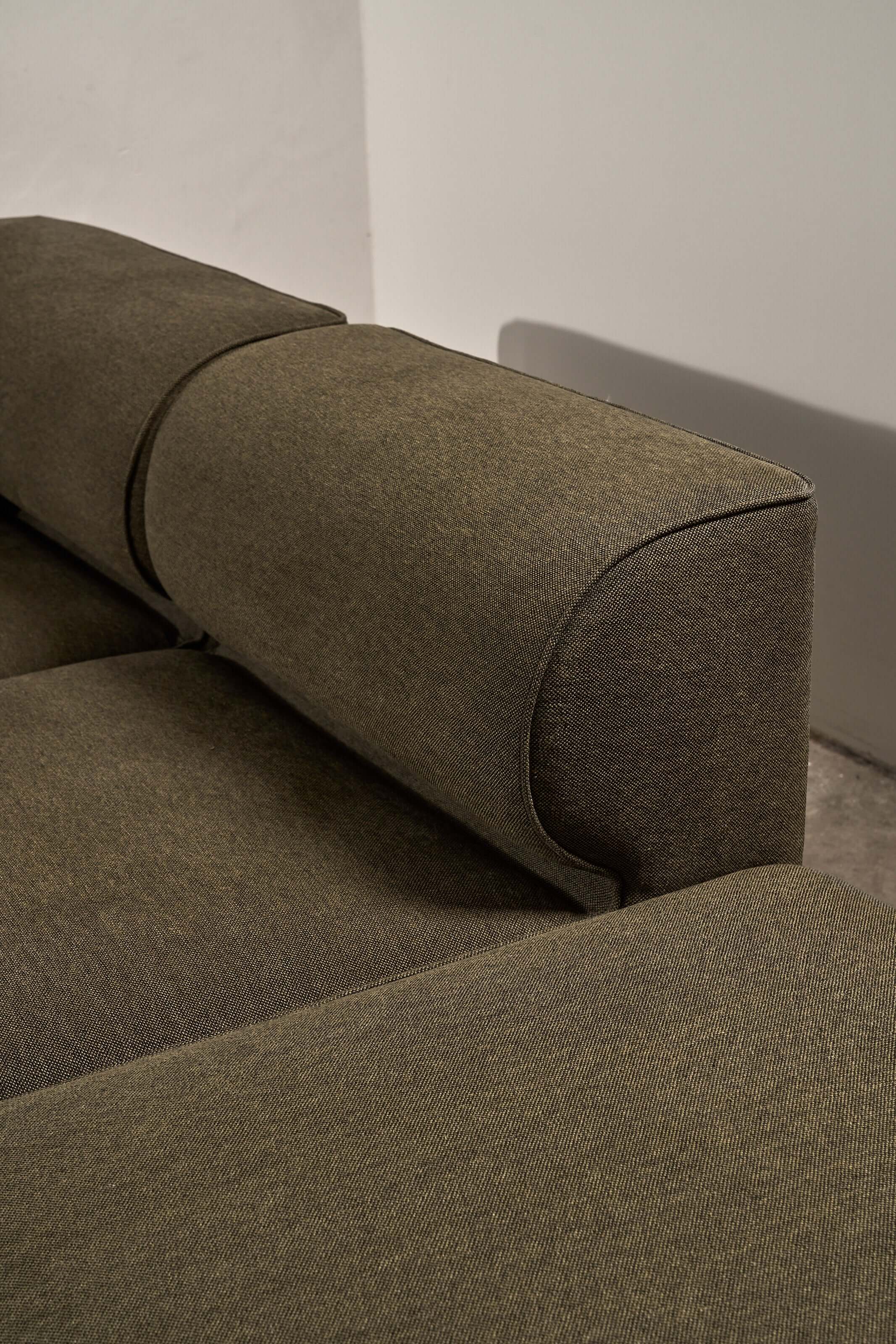 Eave Modular Sofa by Norm Architects in Grey Green, showcasing its curved backrest and textured fabric detail.