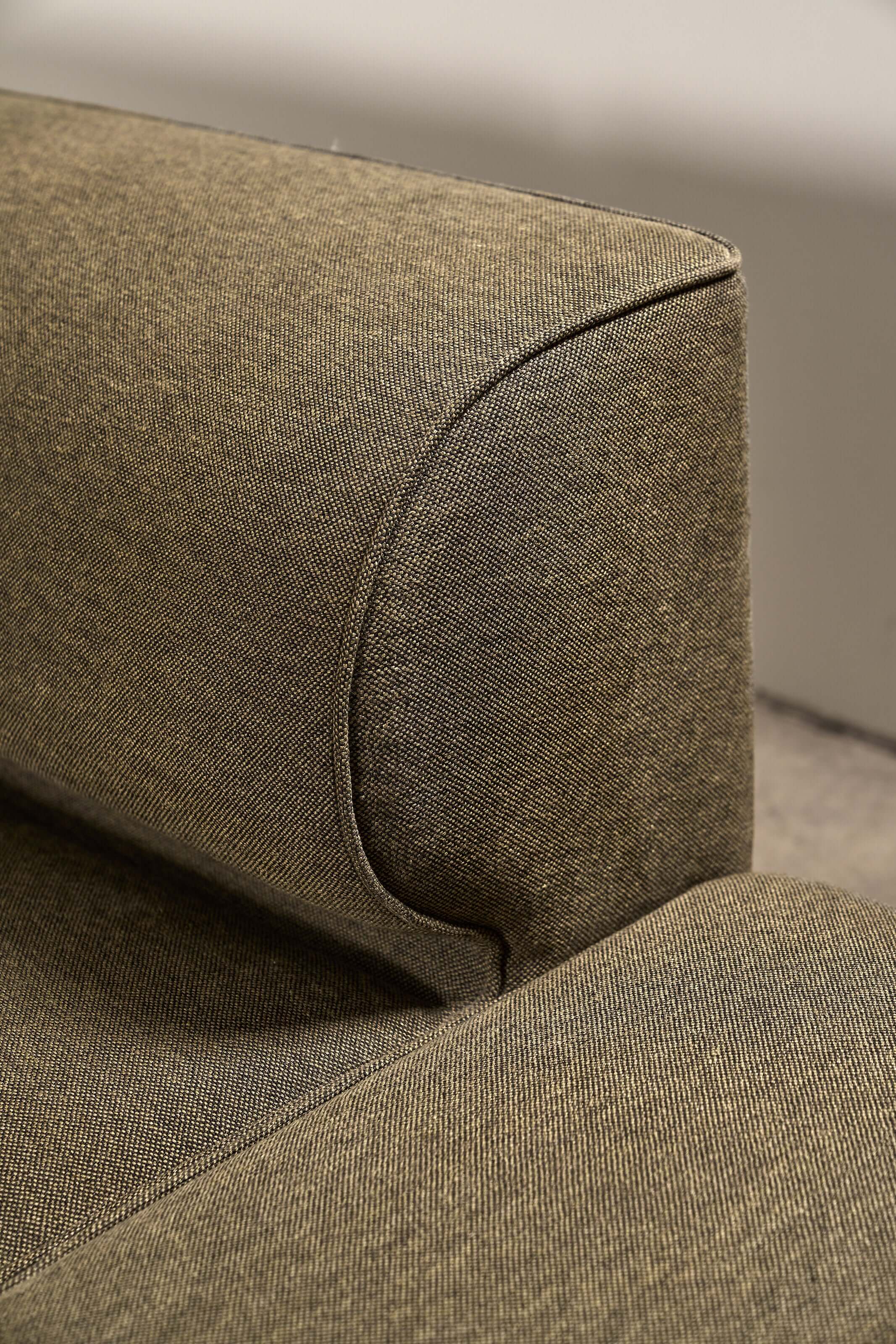 Close-up of the Eave Modular Sofa by Norm Architects in Grey Green, showcasing the curved backrest and textured fabric.