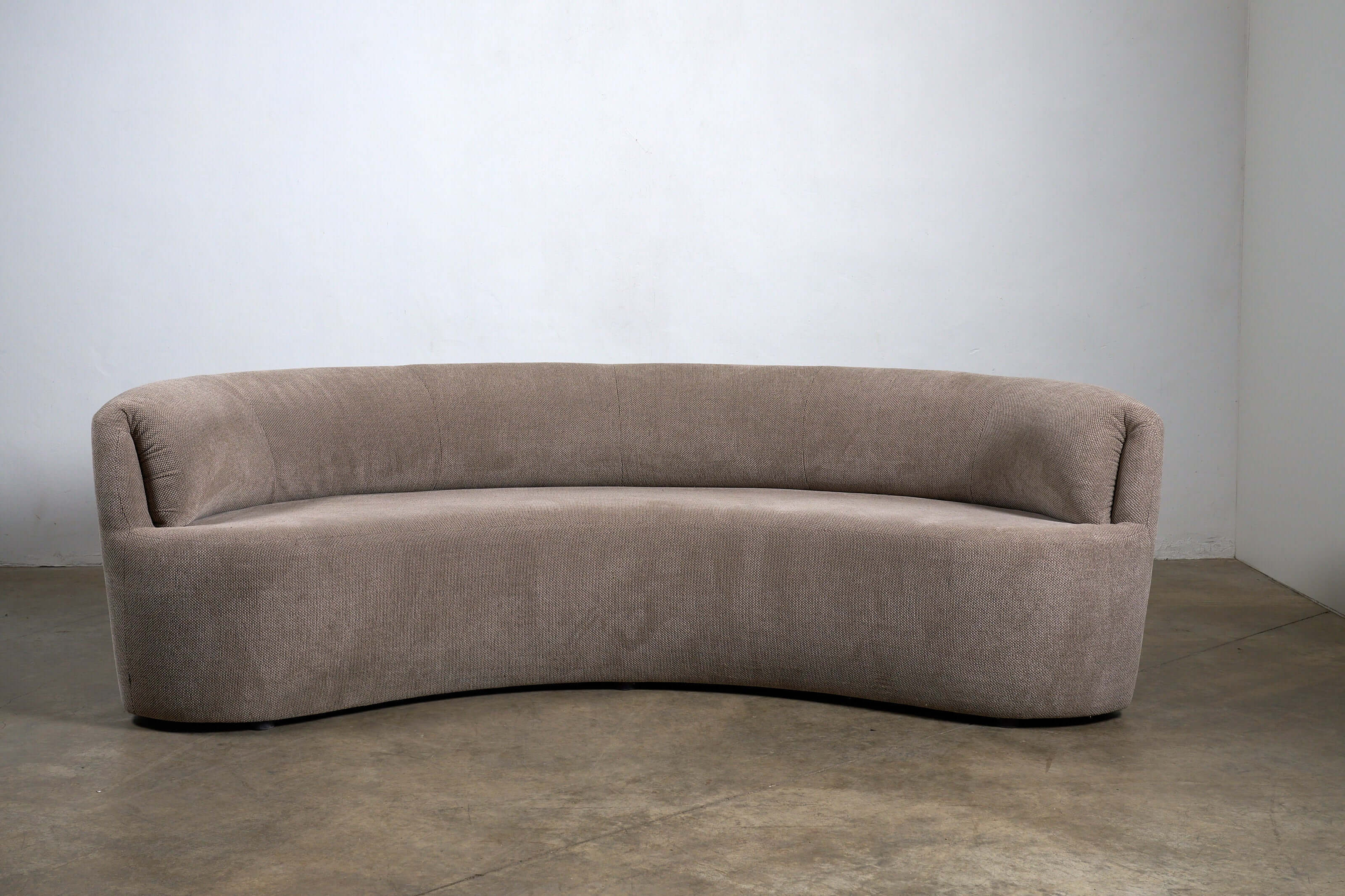 Organic Modern Curved Fabric Sofa with a distinct crescent silhouette in textured beige upholstery.