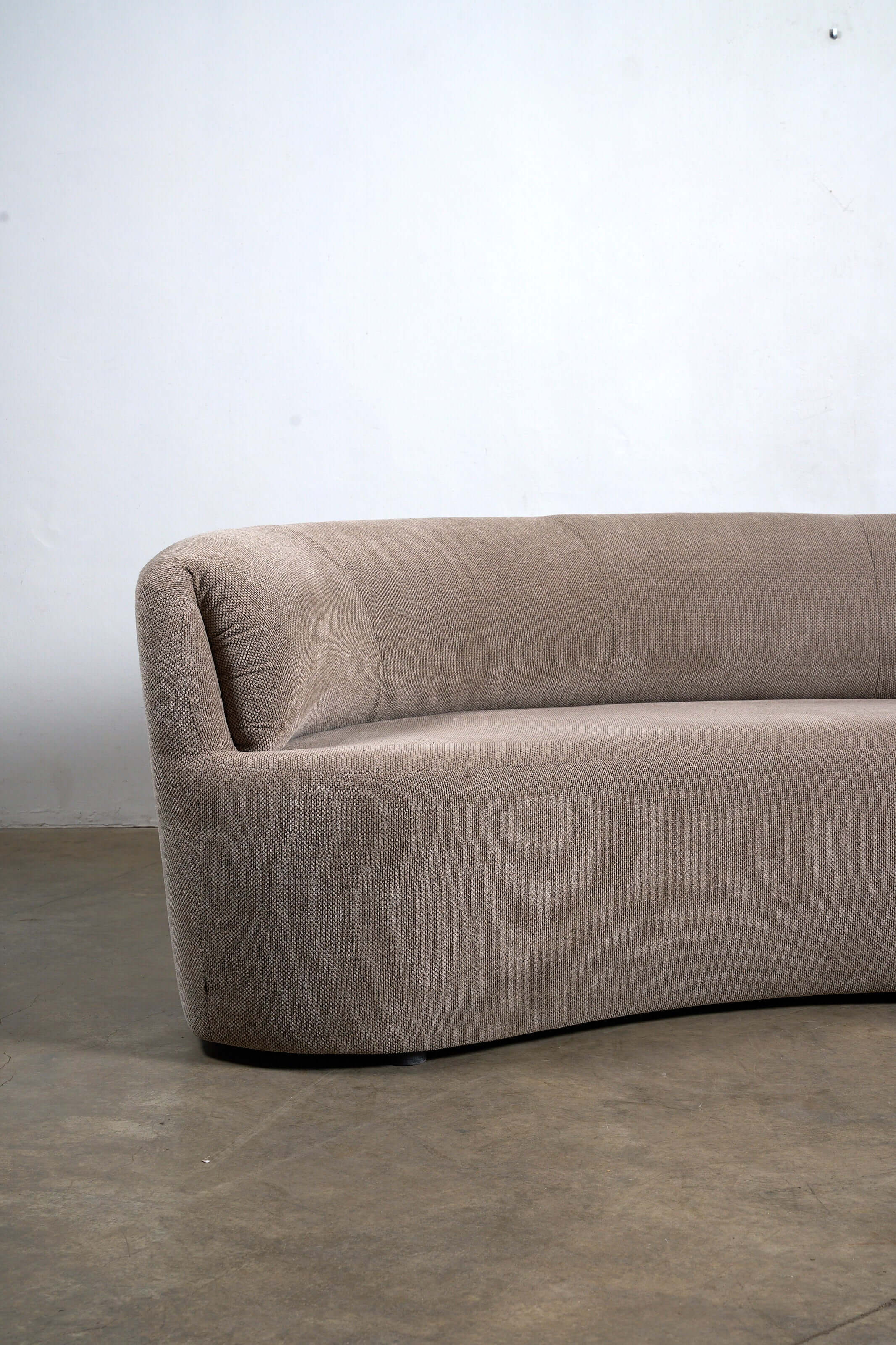Organic Modern Curved Fabric Sofa with a textured beige upholstery and a sculptural crescent shape.