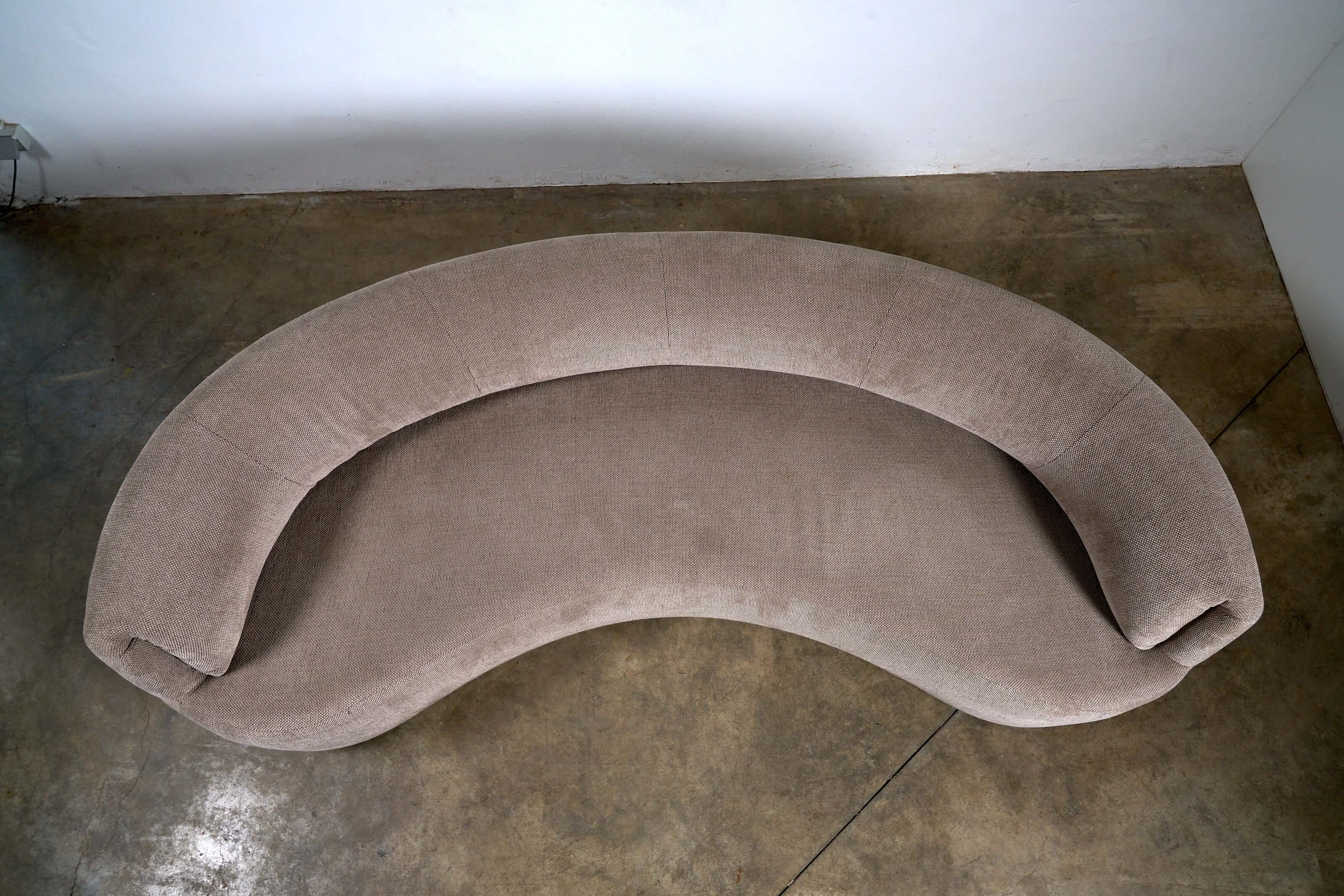Organic Modern Curved Fabric Sofa viewed from above, showcasing its distinct crescent shape and textured beige upholstery.