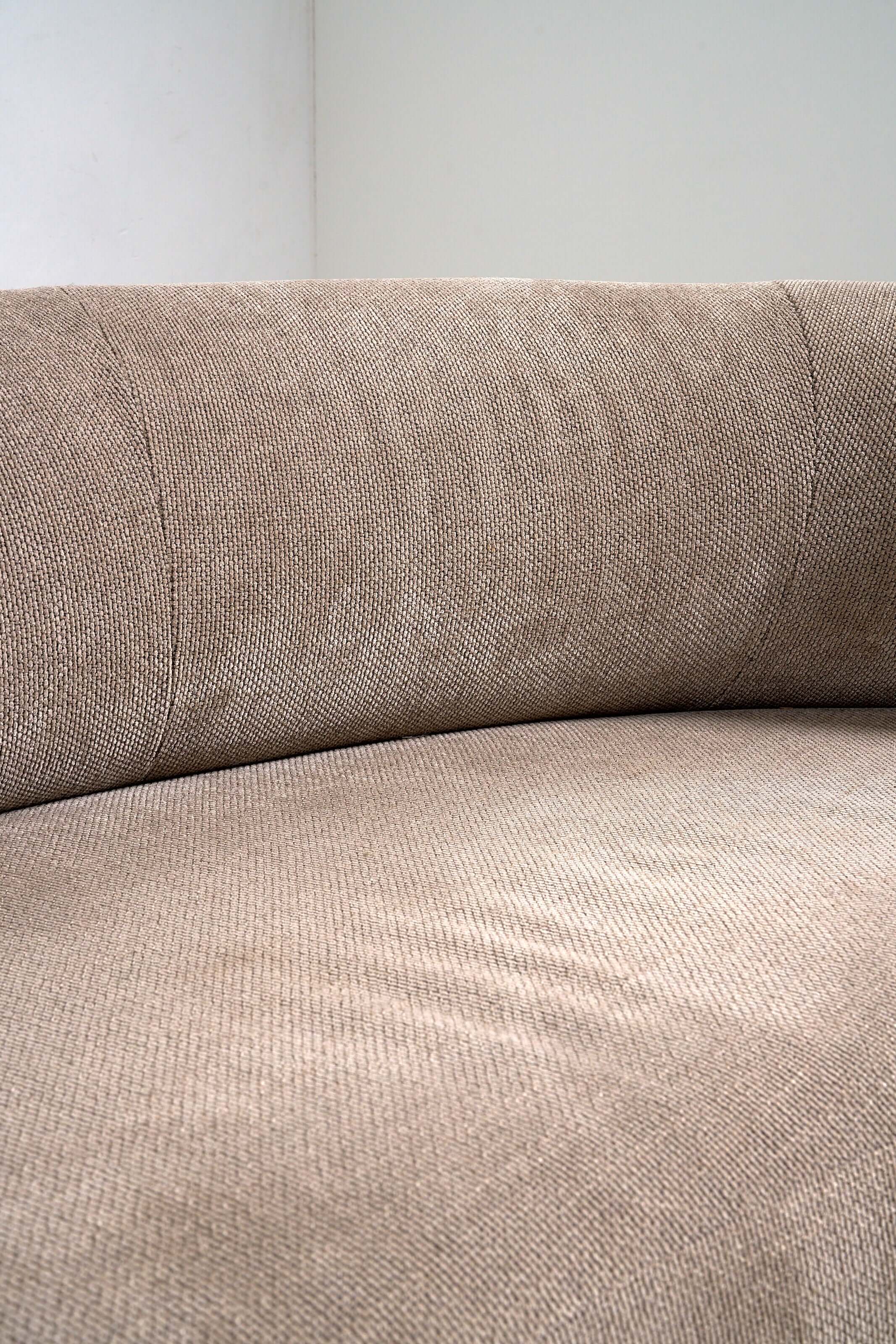 Close-up of the textured fabric on an Organic Modern Curved Fabric Sofa with a continuous backrest.