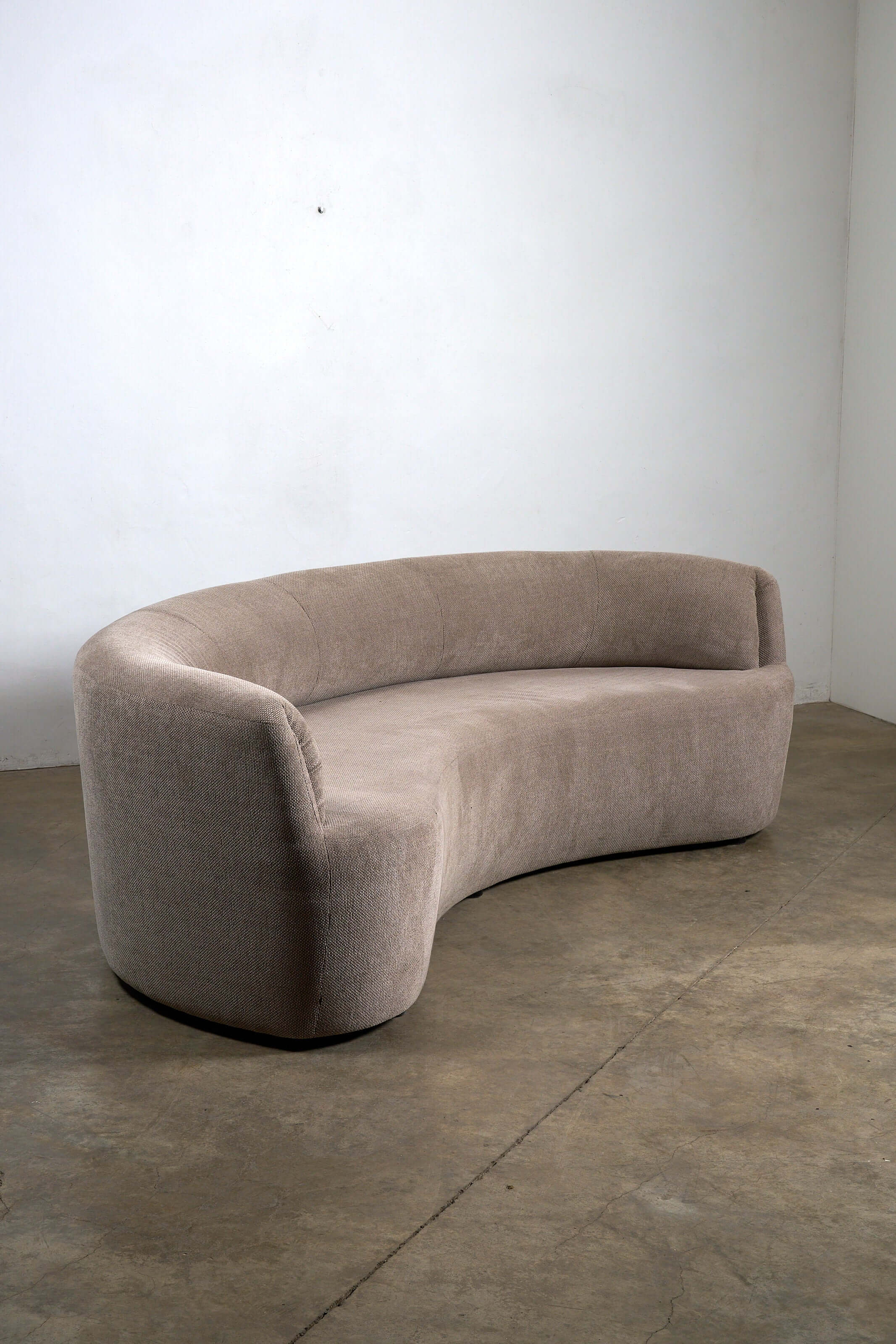 Organic Modern Curved Fabric Sofa with a crescent silhouette and textured beige fabric upholstery.