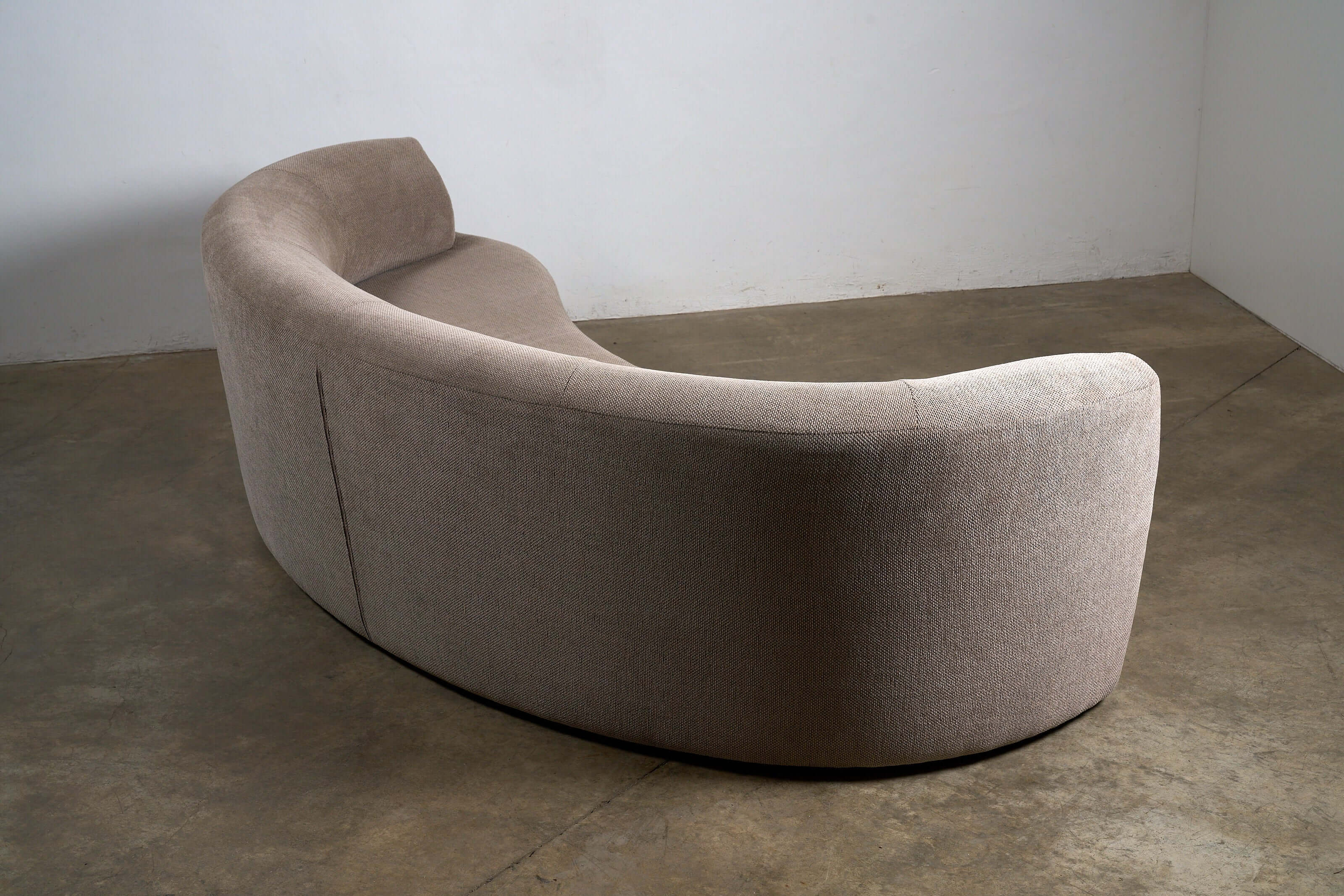 Organic Modern Curved Fabric Sofa in a textured beige fabric with a distinct crescent shape and sculptural lines.