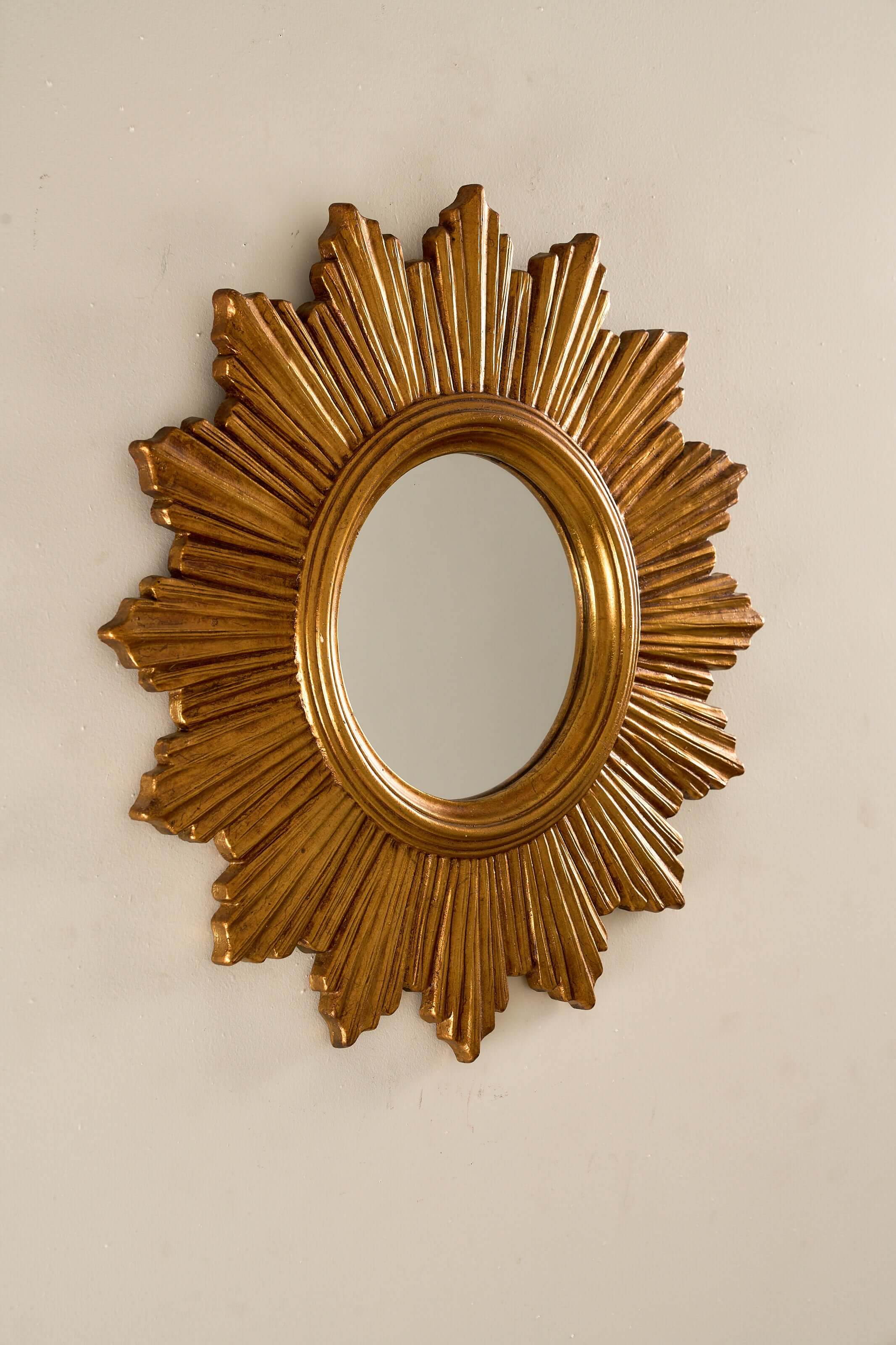 1960s European Epoxy Sunburst Mirror with sculptural gold-toned frame and central flat mirror plate.