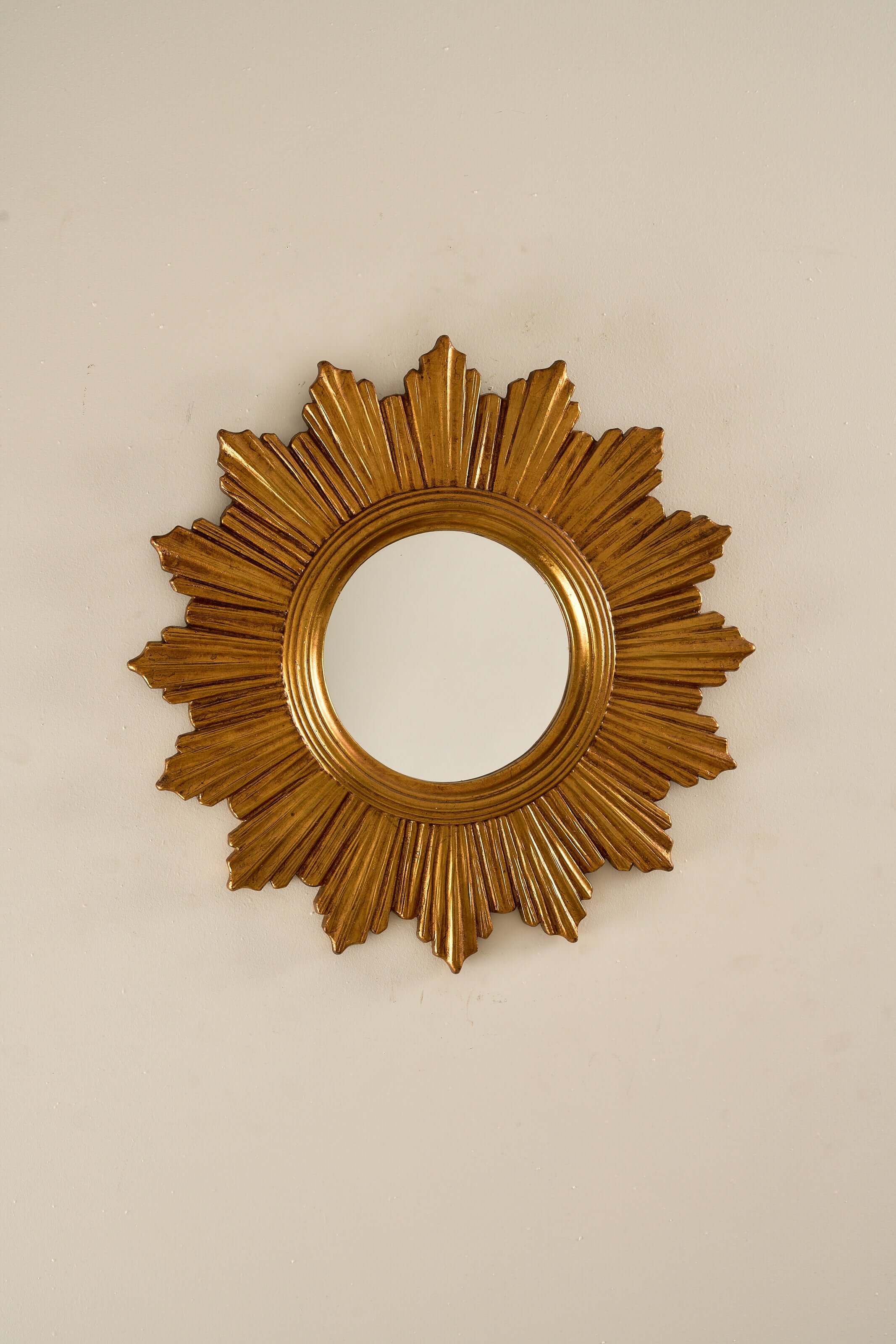 1960s European Epoxy Sunburst Mirror with a sculptural gold-toned frame and layered circular design.