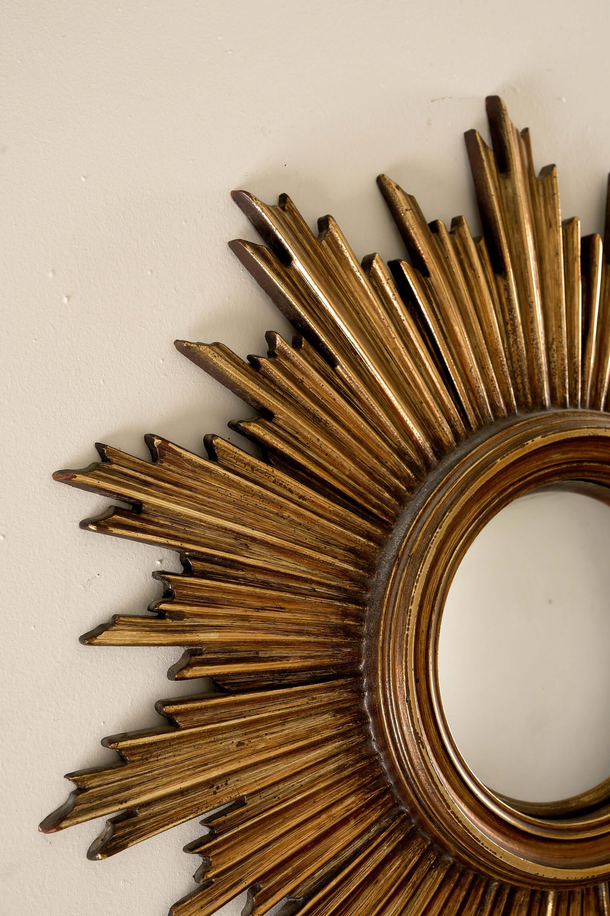 Mid-Century Gilt Wood Sunburst Mirror, 1960s with jagged rays and a convex center.