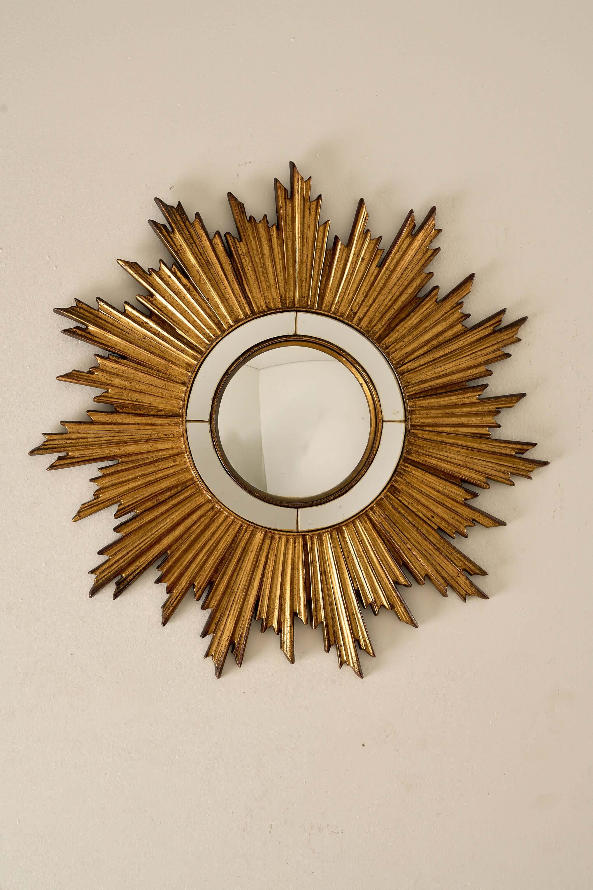Mid-Century Gilt Wood Sunburst Mirror, 1960s with a jagged starburst motif and convex center.