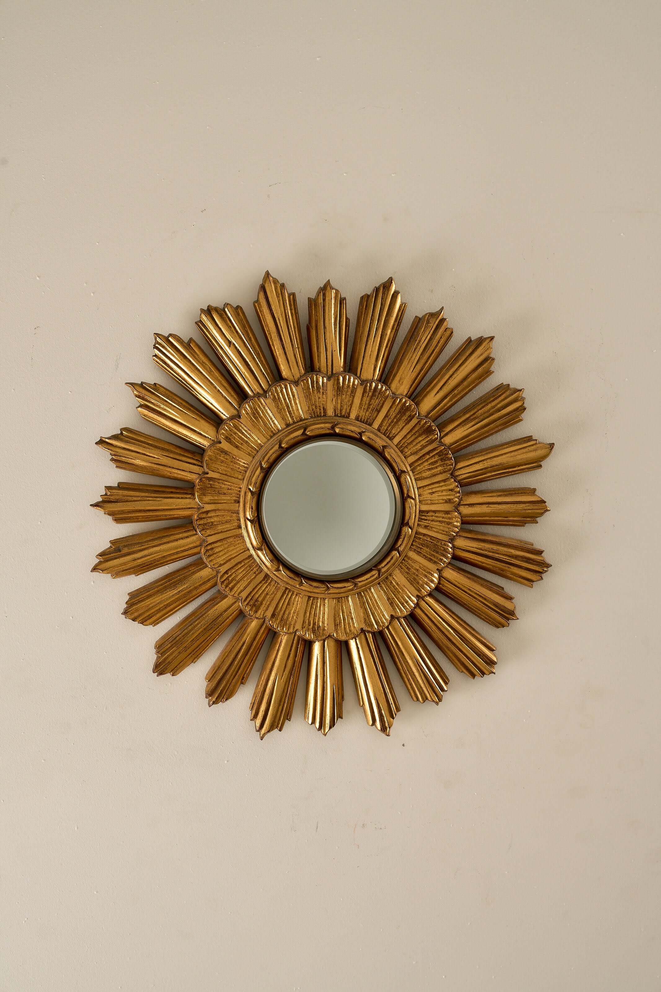Mid-Century Plaster Sunburst Mirror, 1960s featuring gilded layered rays and central glass mirror.