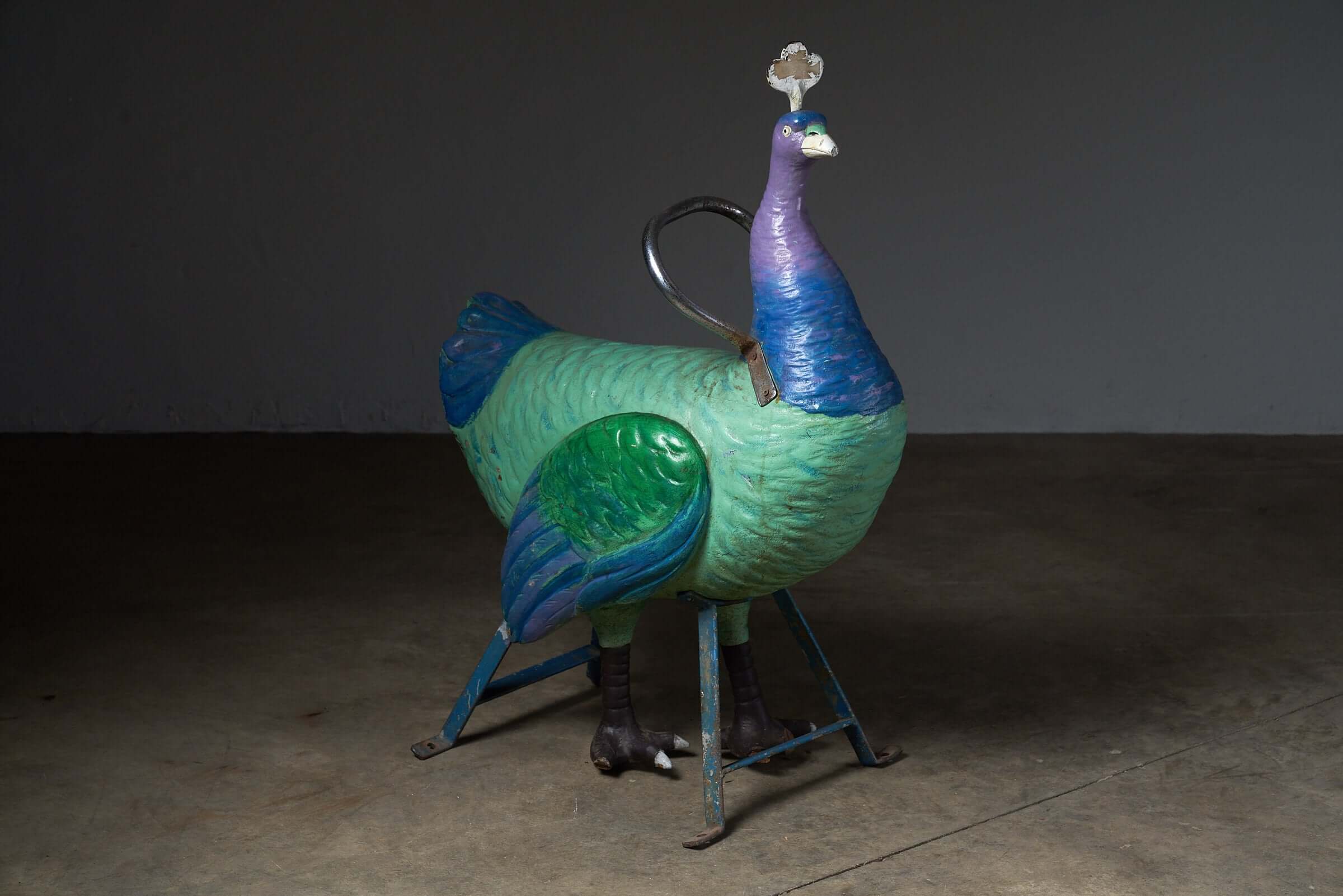 Antique Carnival Ride Peacock Sculpture depicting a hand-carved peacock on a metal frame, ideal for decor.