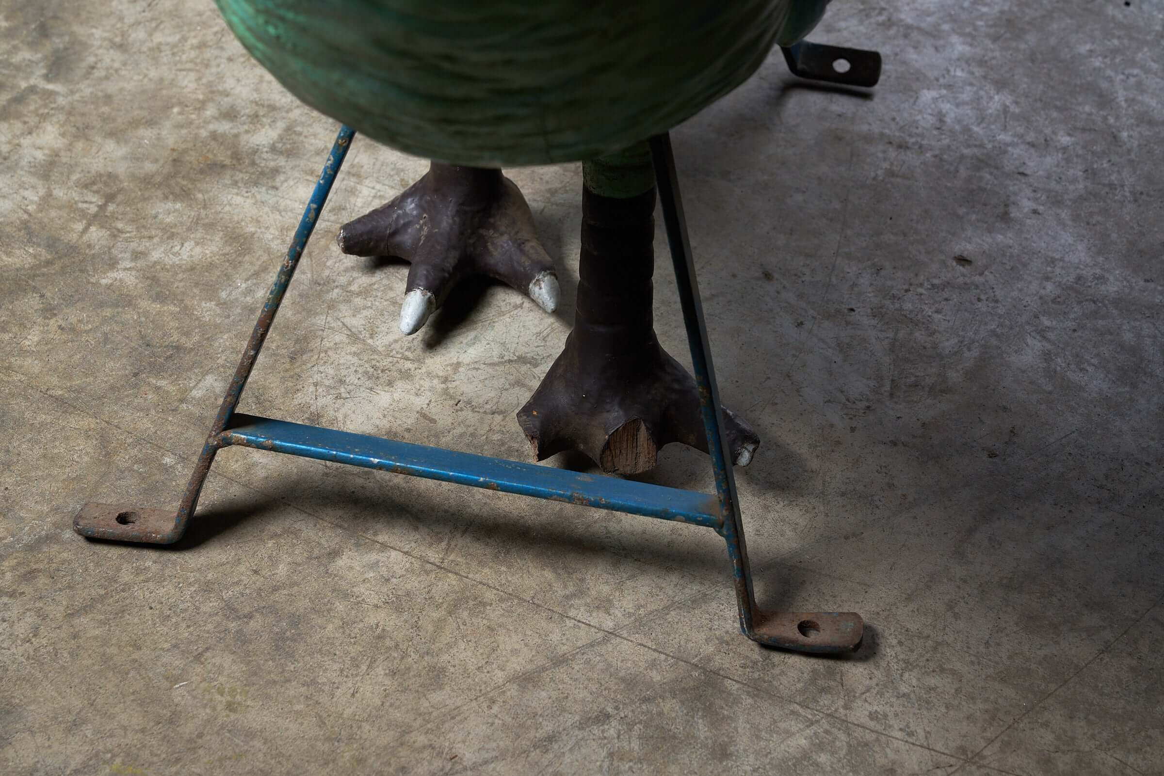Close-up of the metal support frame and wooden feet of the Antique Carnival Ride Peacock Sculpture.