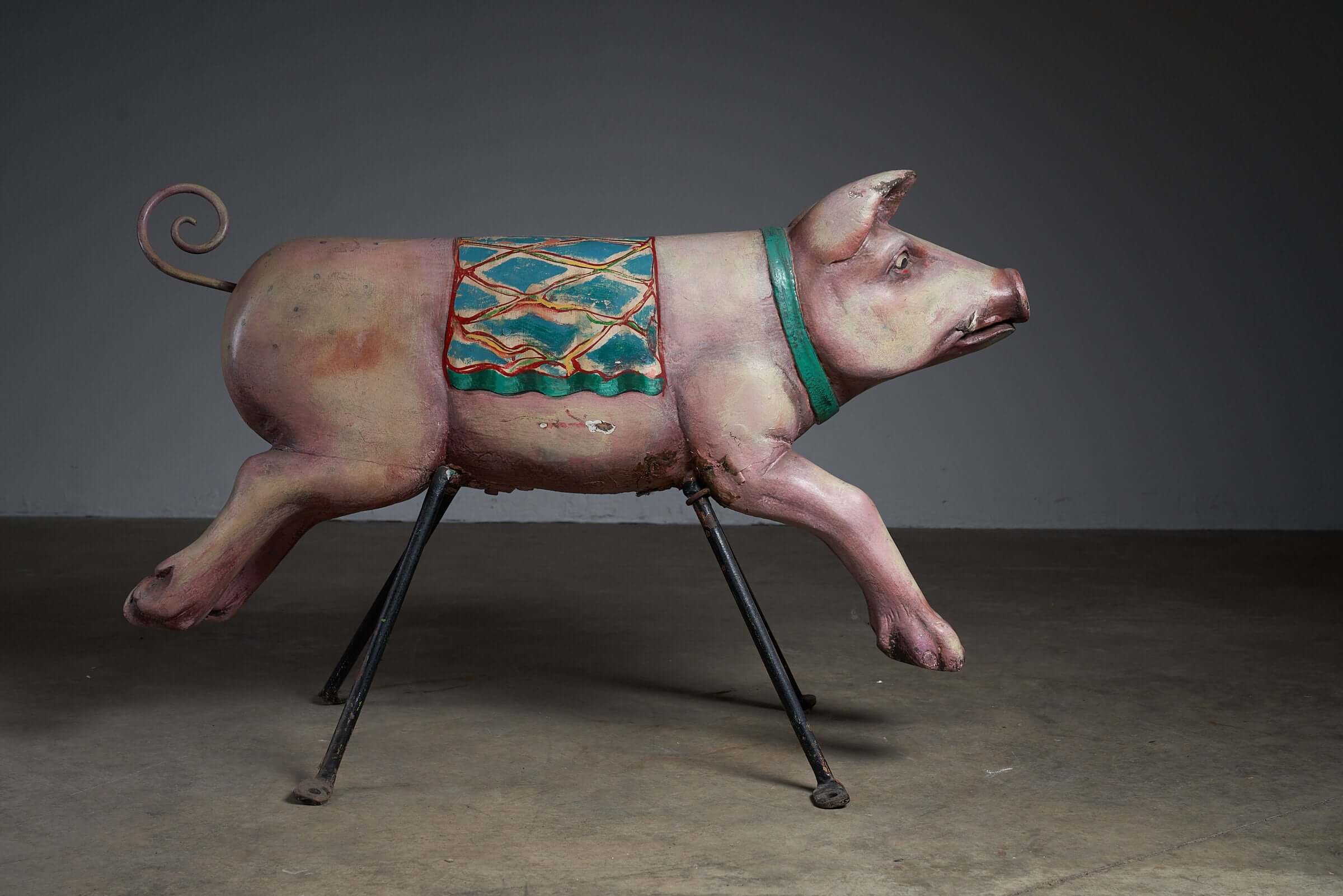 Carved Wooden Carousel Pig Figure with decorative saddle and colorful paint on a metal frame, ideal for folk art display.