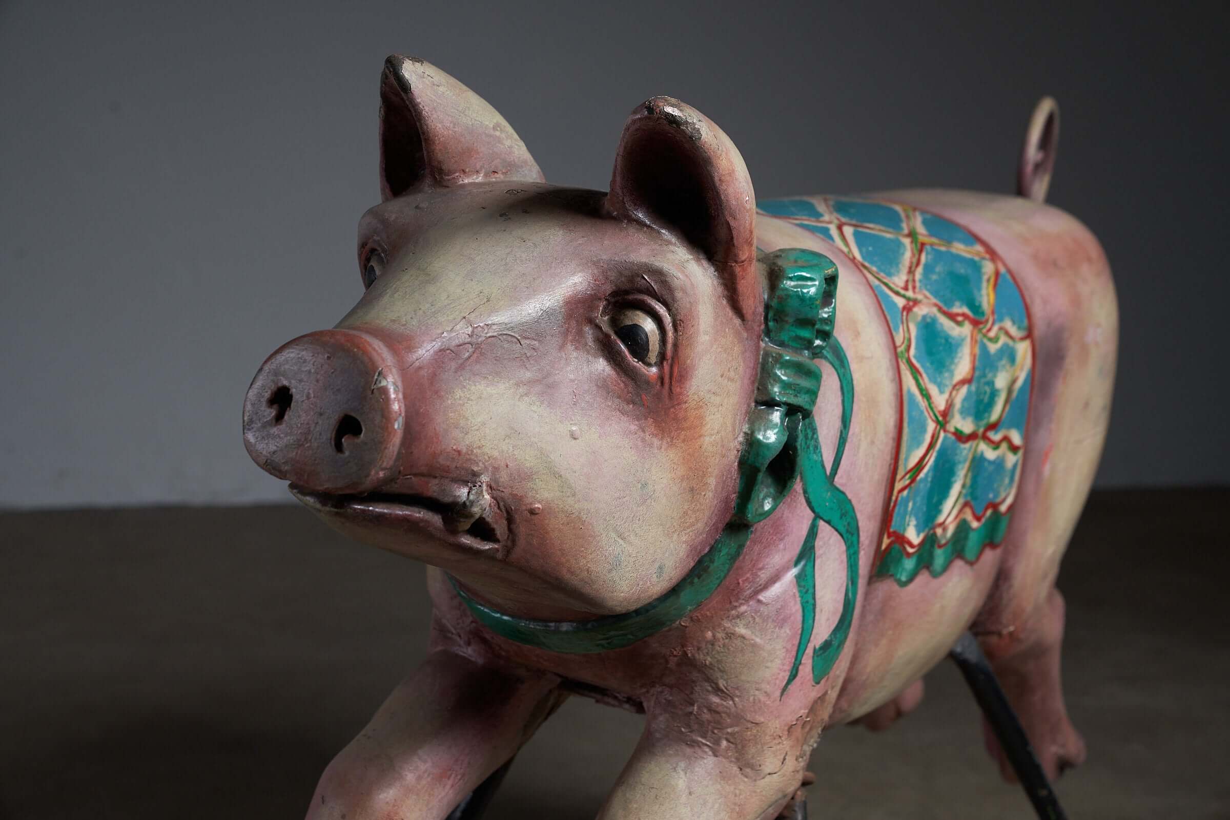 Carved Wooden Carousel Pig Figure close-up, featuring colorful painted details and a decorative saddle, ideal for decor.