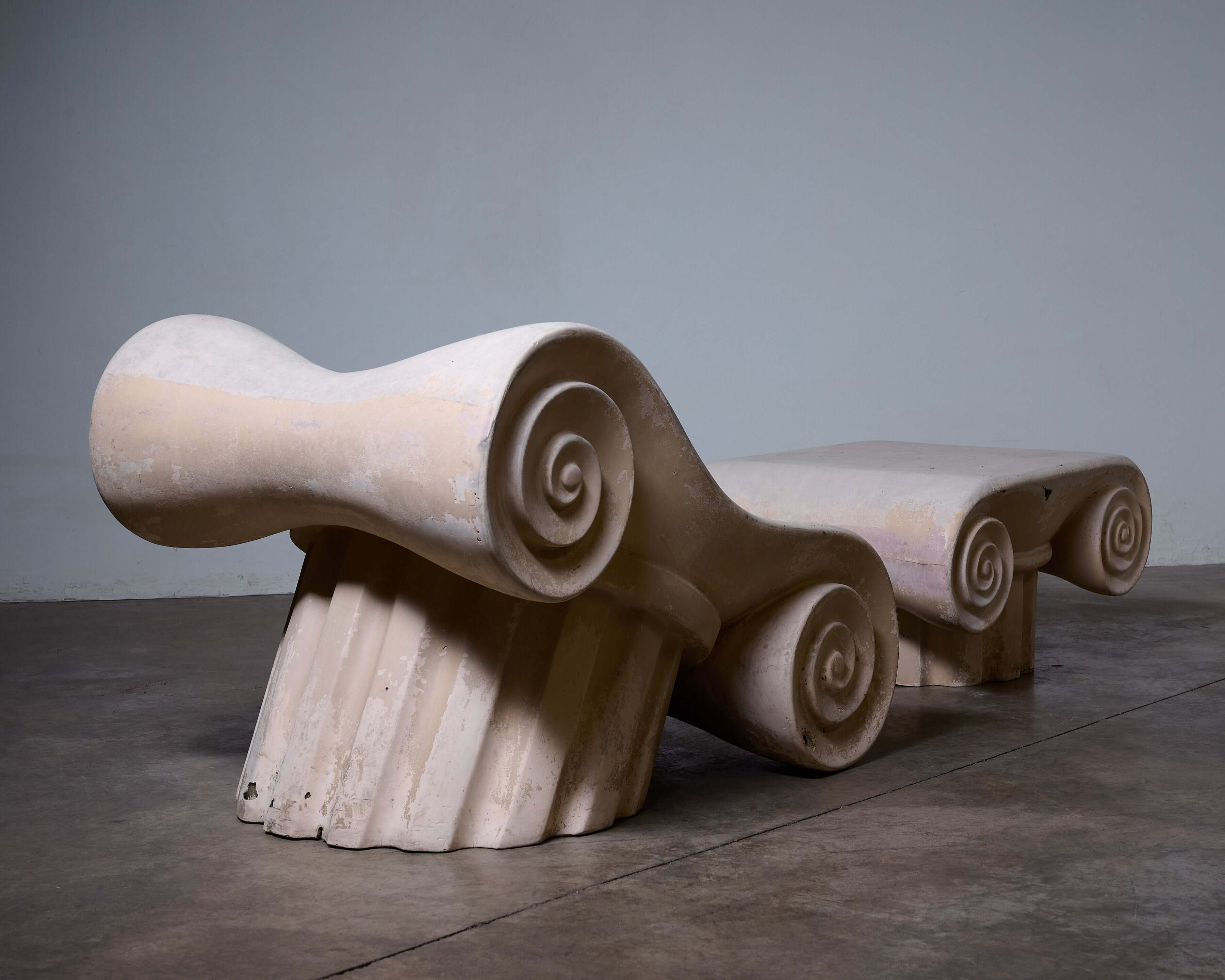 'Capitello' Chair with Ottoman in a minimalist setting, inspired by ancient Greek architectural elements.