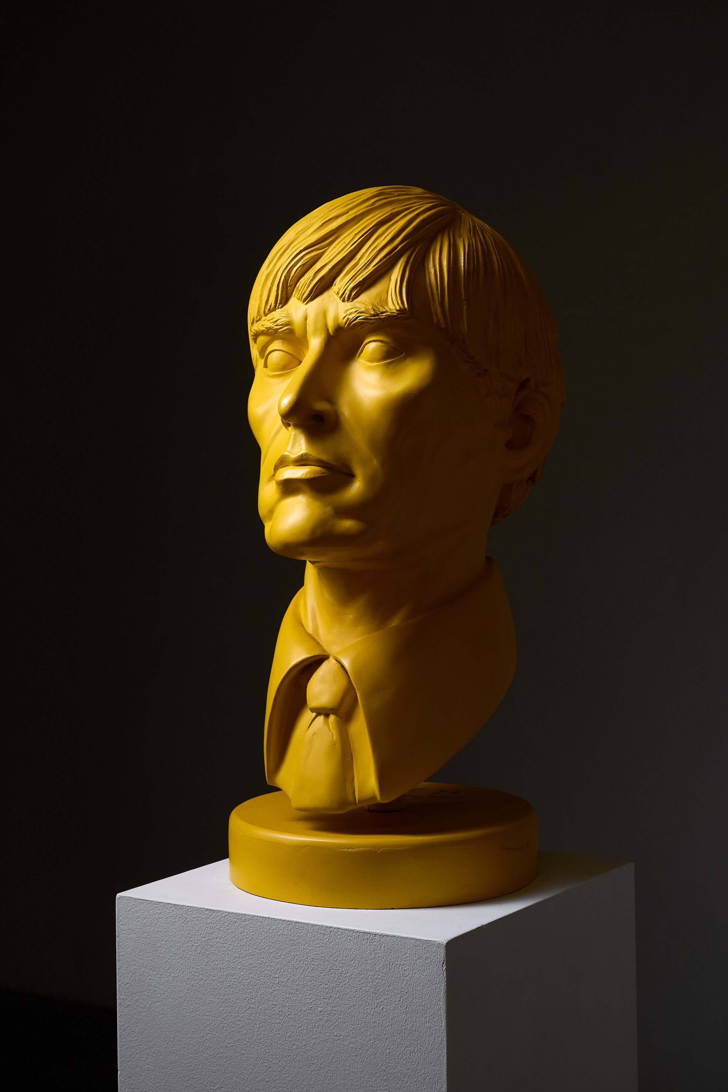 Andy Warhol' Sculpture by Leonardo displayed on a pedestal, showcasing a pop art bust in vibrant yellow.