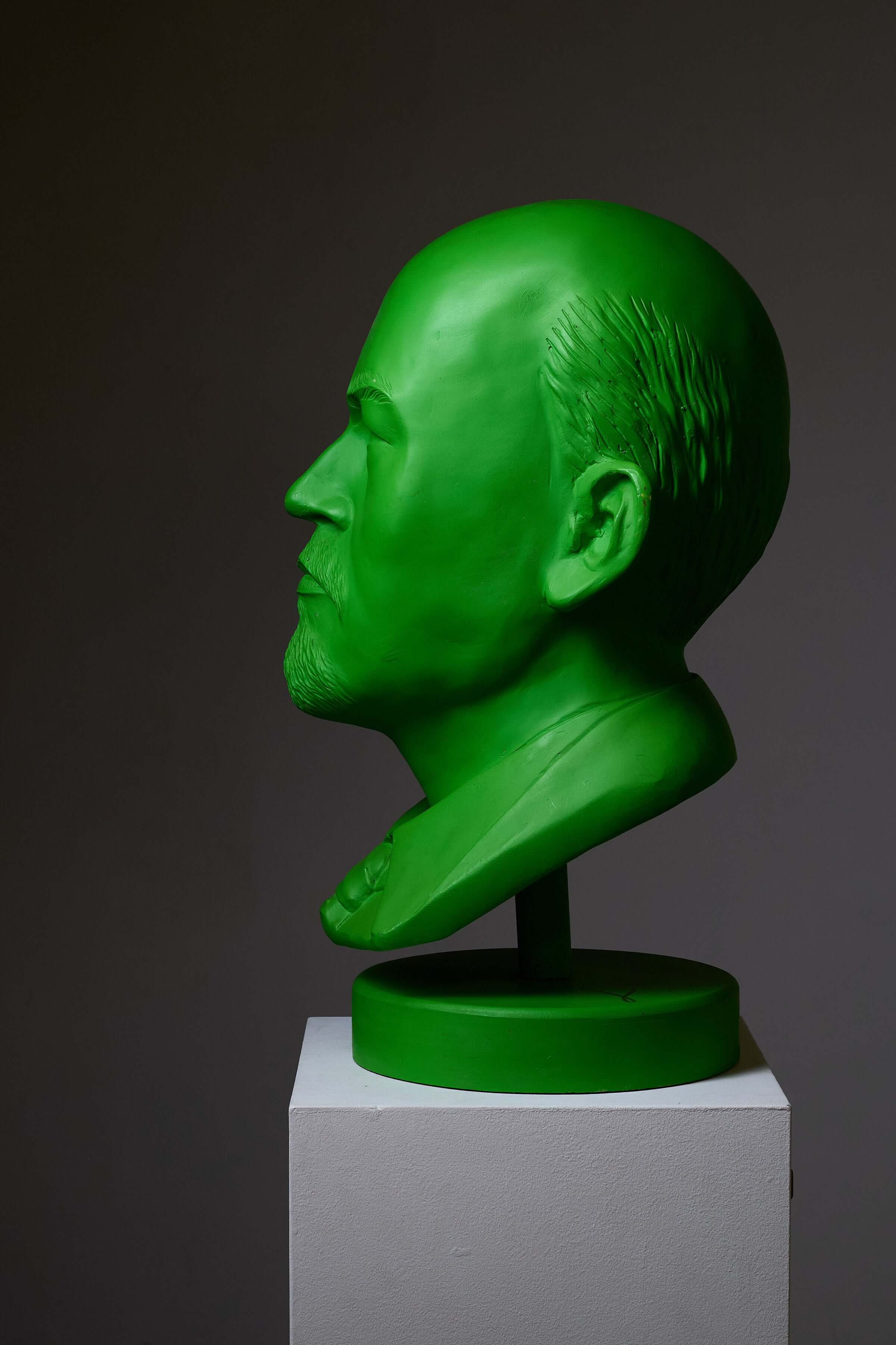 Vladimir Lenin Sculpture by Leonardo in bright green color, displayed on a pedestal.