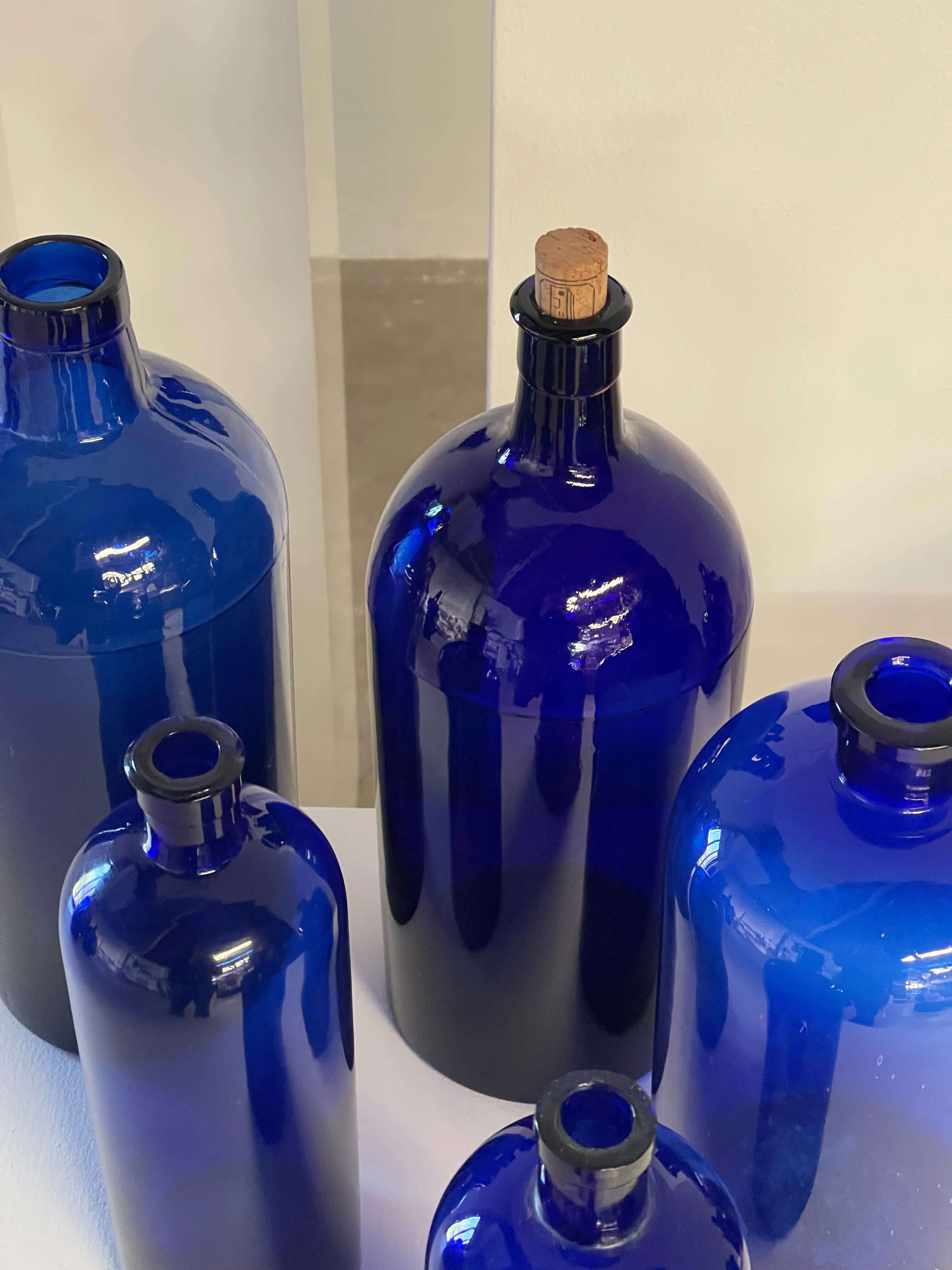 Collection of Antique Cobalt Blue Essence and Apothecary Bottles featuring various cobalt blue glass designs.