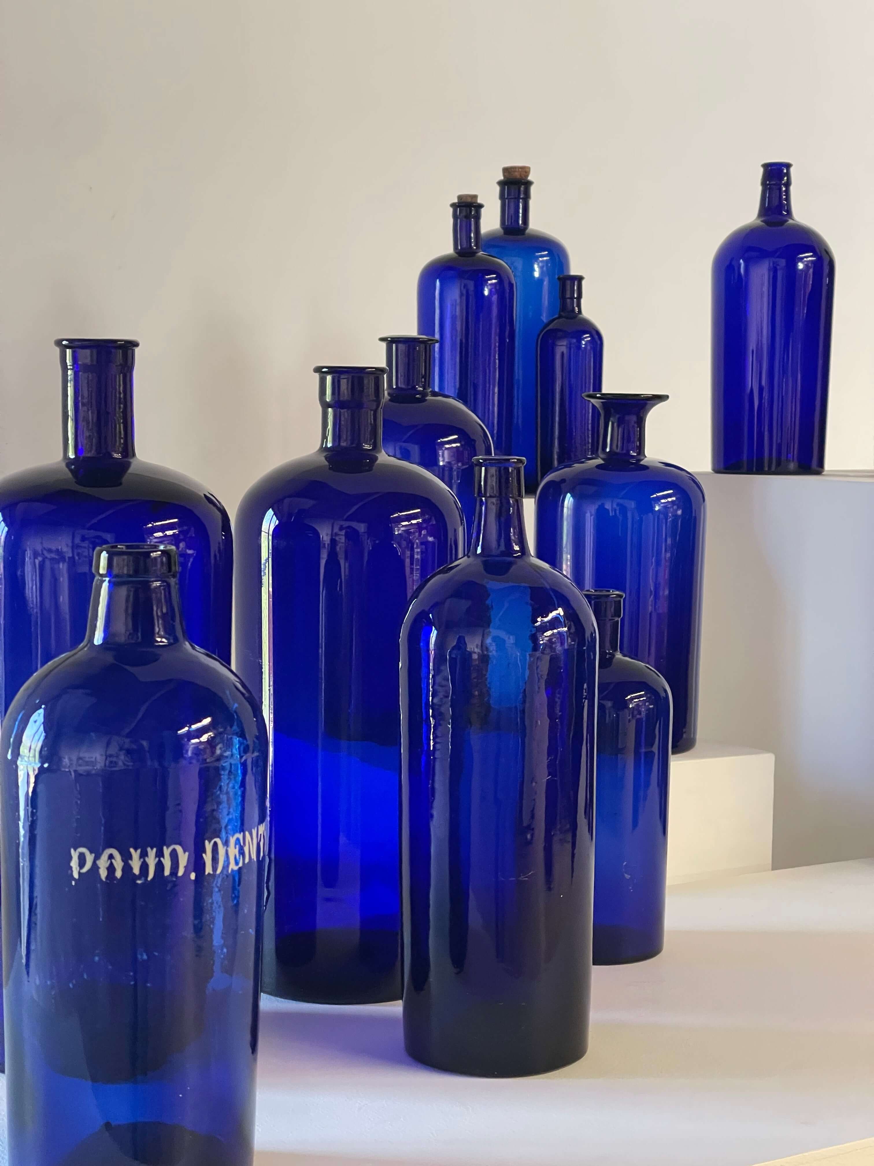 Collection of Antique Cobalt Blue Essence and Apothecary Bottles featuring various cobalt blue glass jars.
