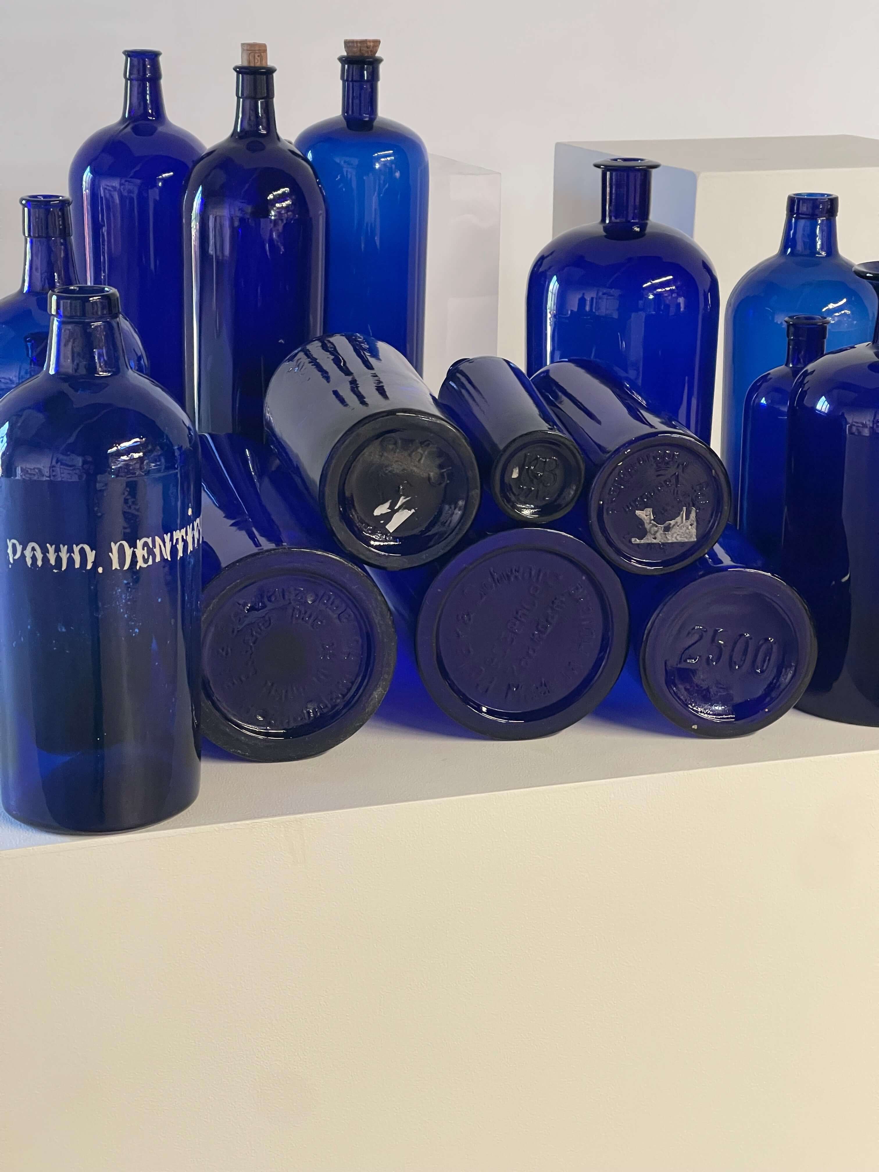 Collection of Antique Cobalt Blue Essence and Apothecary Bottles featuring various blue glass bottles and jars.